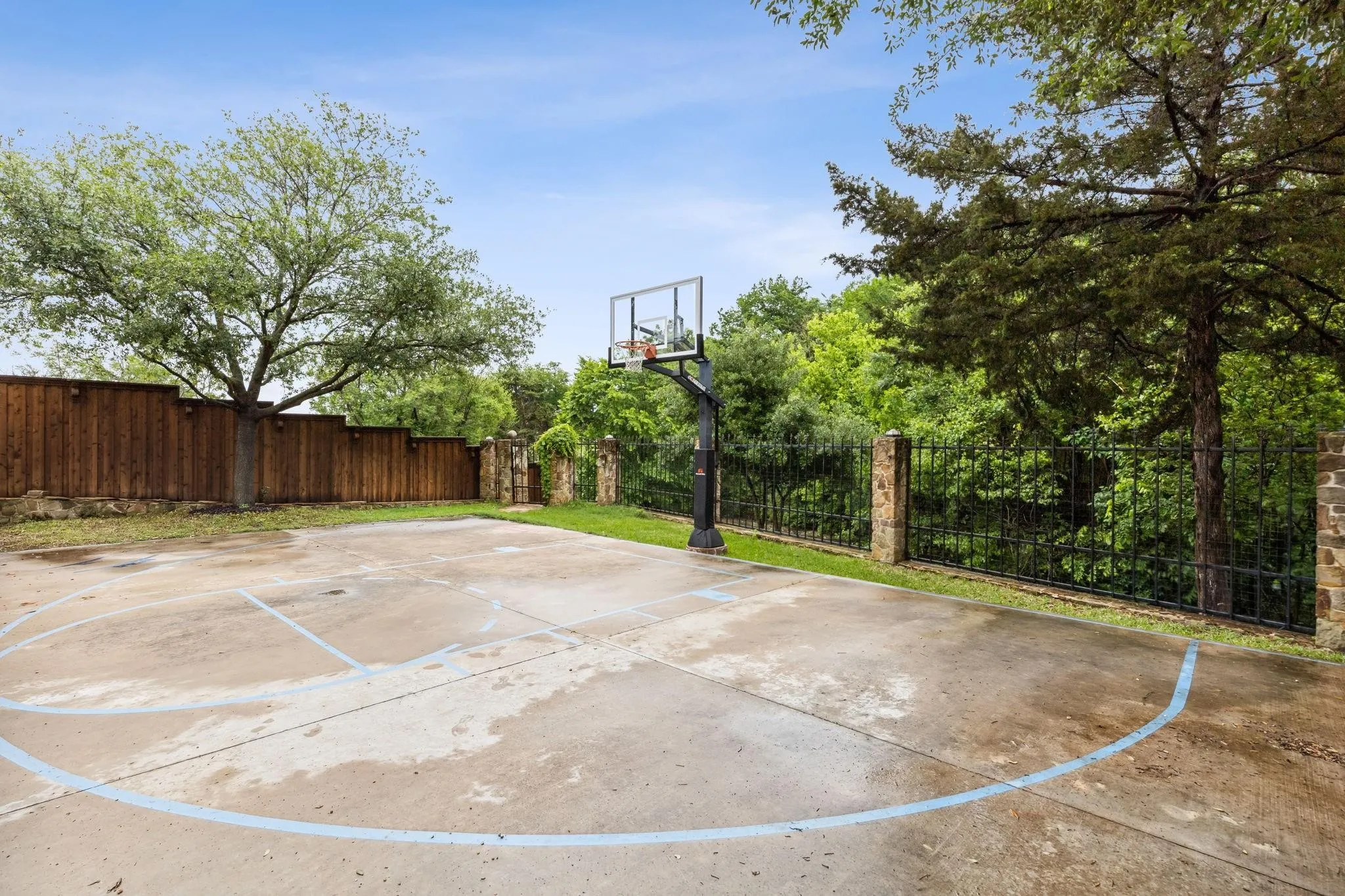 View of basketball court with basketball hoop and fence