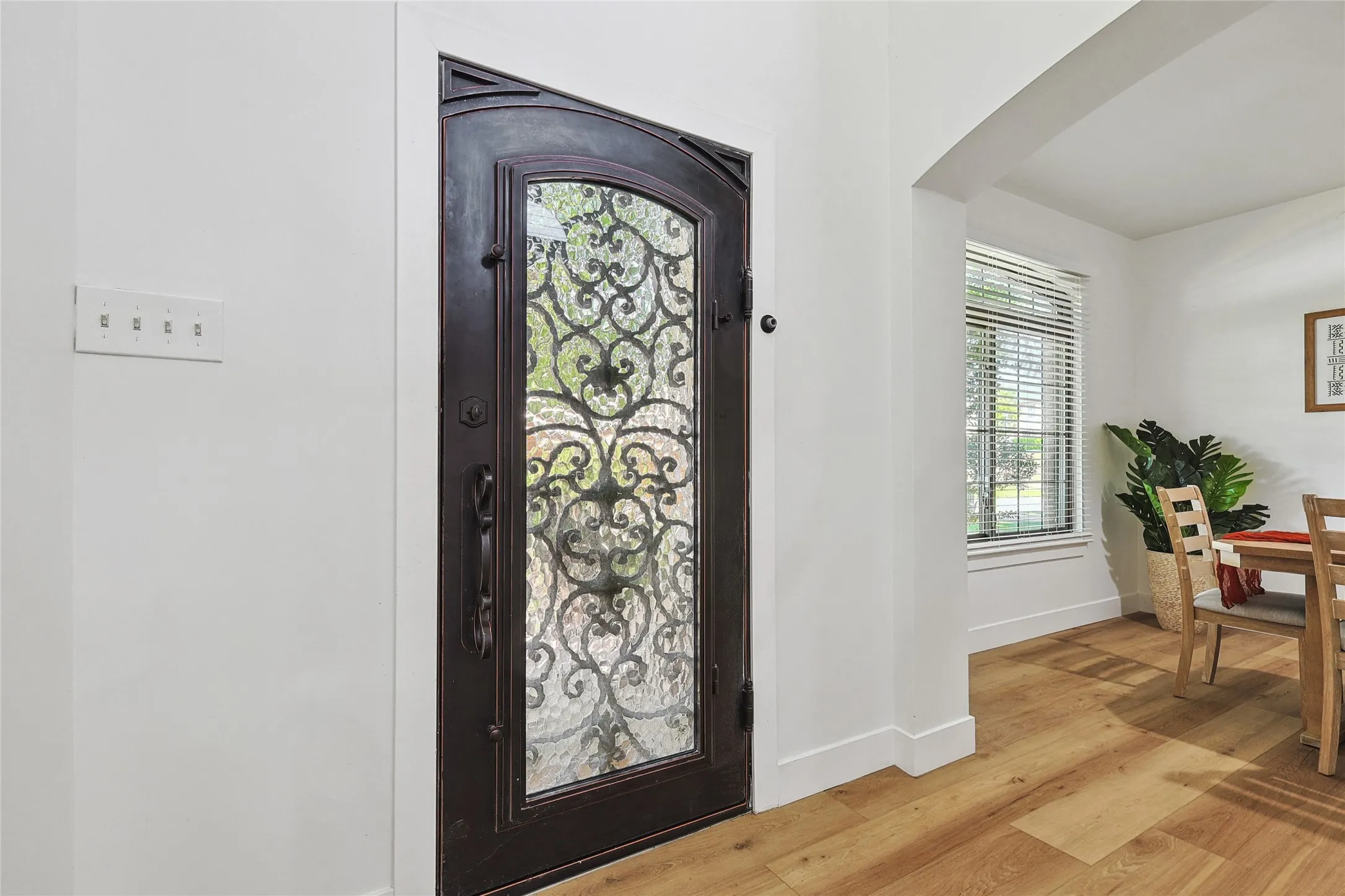 Entryway featuring arched walkways, baseboards, and light wood-type flooring