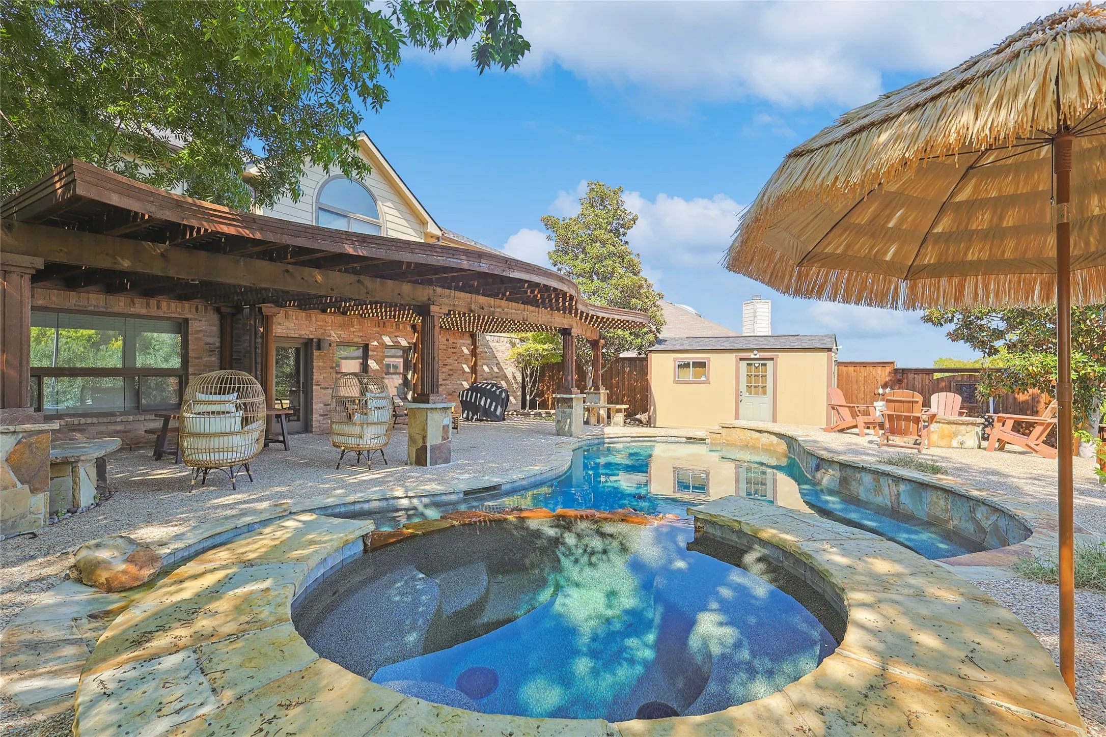 View of pool with a patio, fence, an outdoor structure, and a pool with connected hot tub