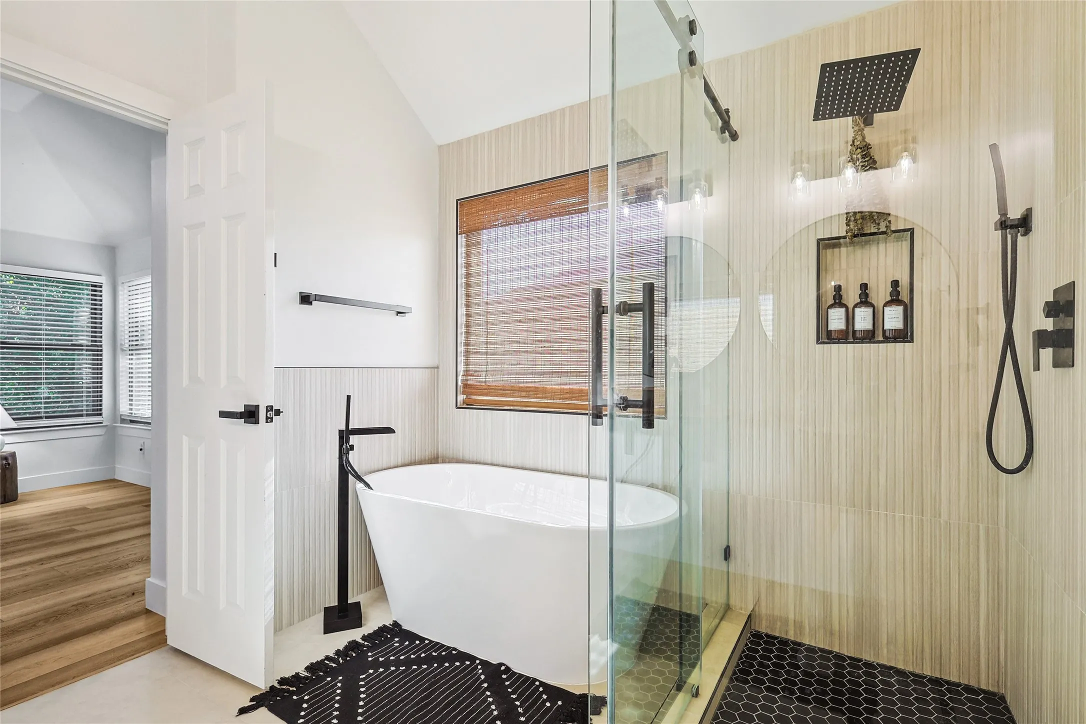 Full bathroom featuring a wainscoted wall, a freestanding tub, vaulted ceiling, and a shower stall