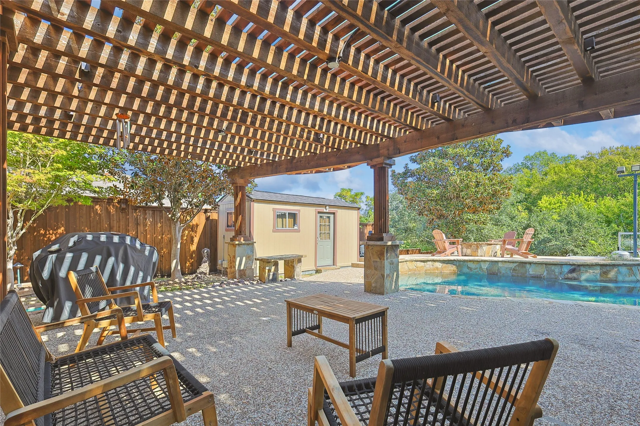 View of patio featuring an outdoor structure, an outdoor pool, a fenced backyard, grilling area, and a pergola