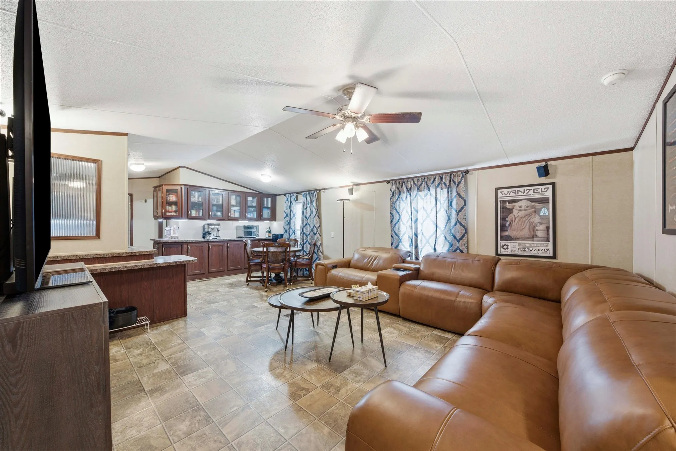 Open-concept living area featuring wood-finish flooring, a vaulted ceiling, and recessed lighting