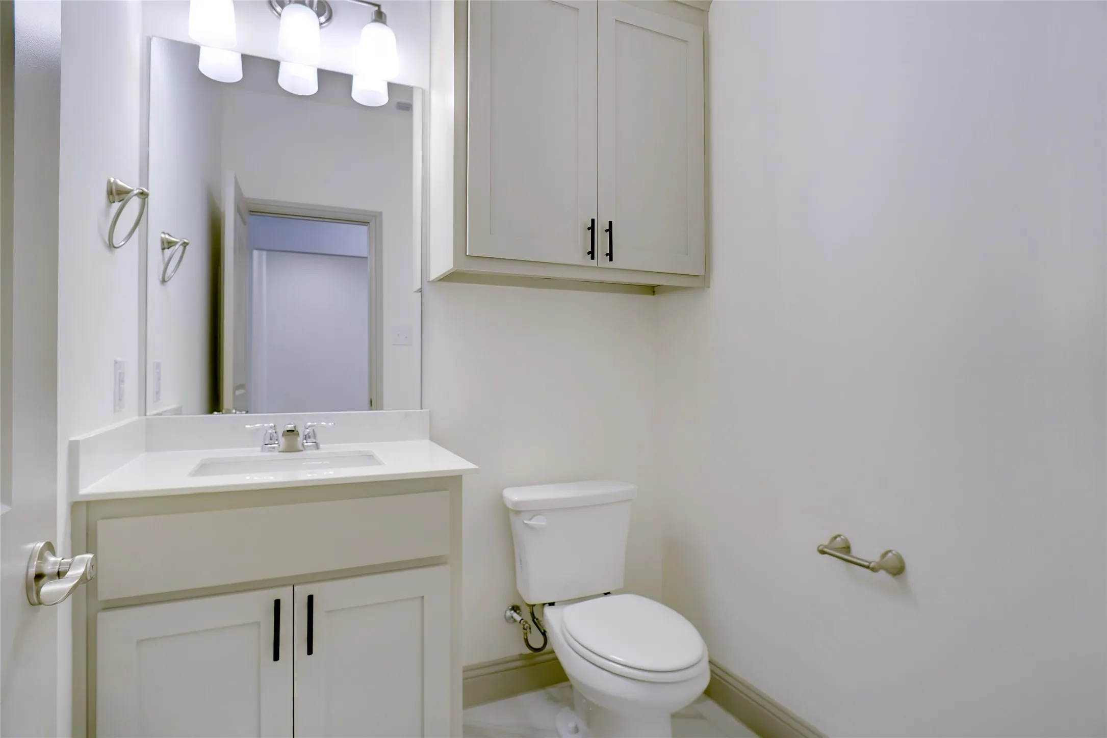Bathroom featuring a vanity with an integrated sink, quartz countertop, and brushed nickel hardware