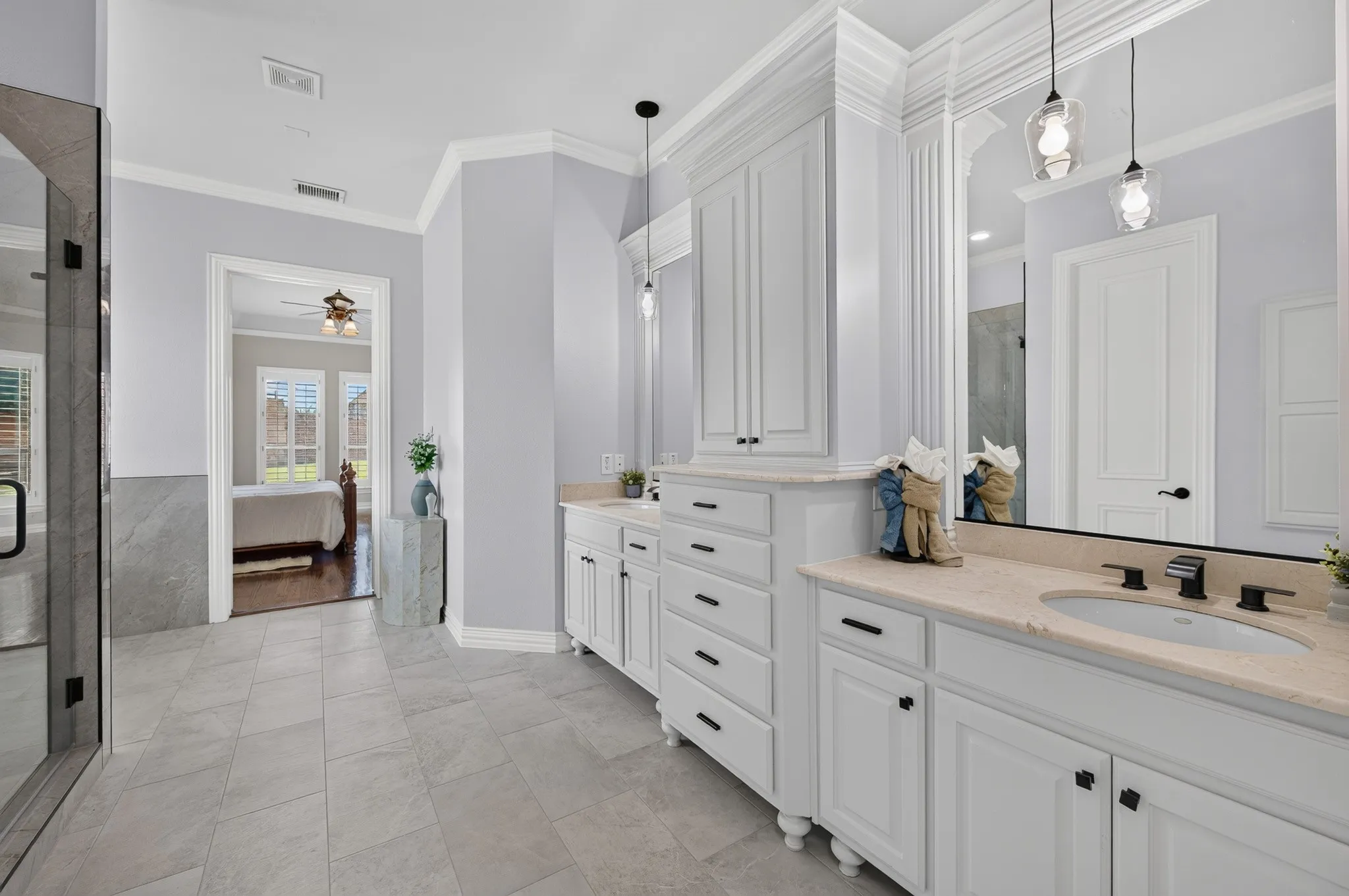 Primary bathroom with dual sinks and ample storage and cabinet space.