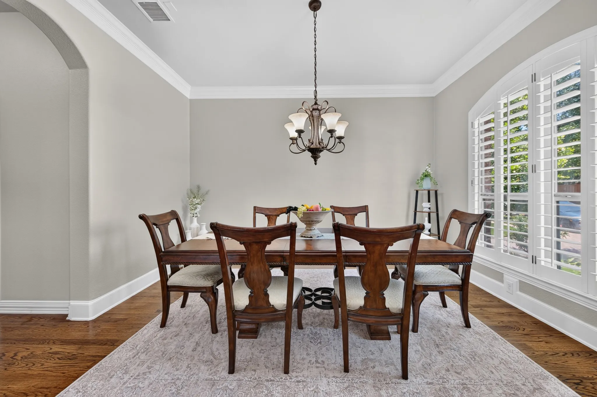 Separate formal dining space complete with fresh paint, crown molding, wood flooring and plantation shutters