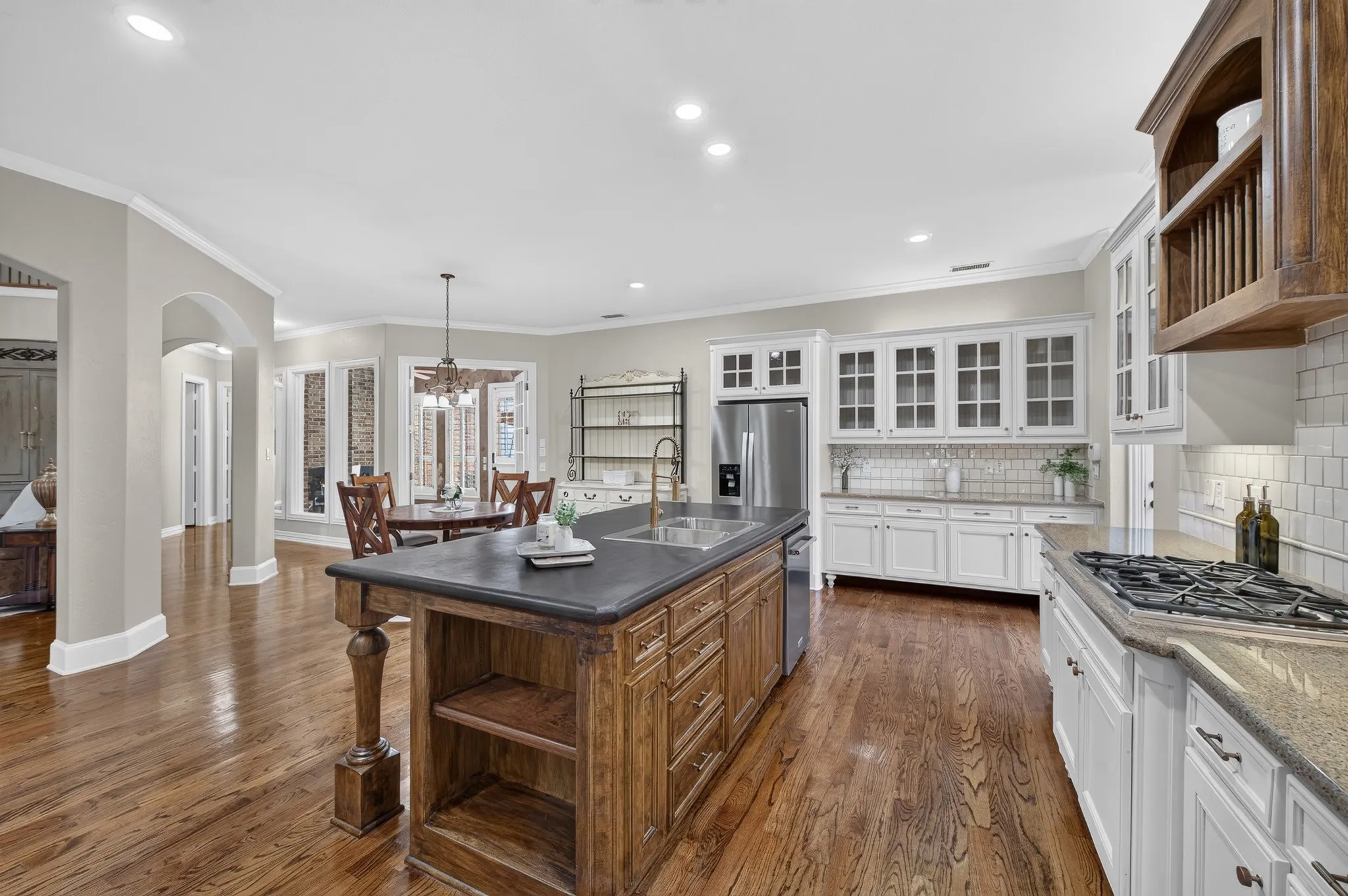 Updated kitchen with freshly painted cabinets, large center island with stone countertop, updated sink and hardware, gas cooktop and ample cabinet space and storage