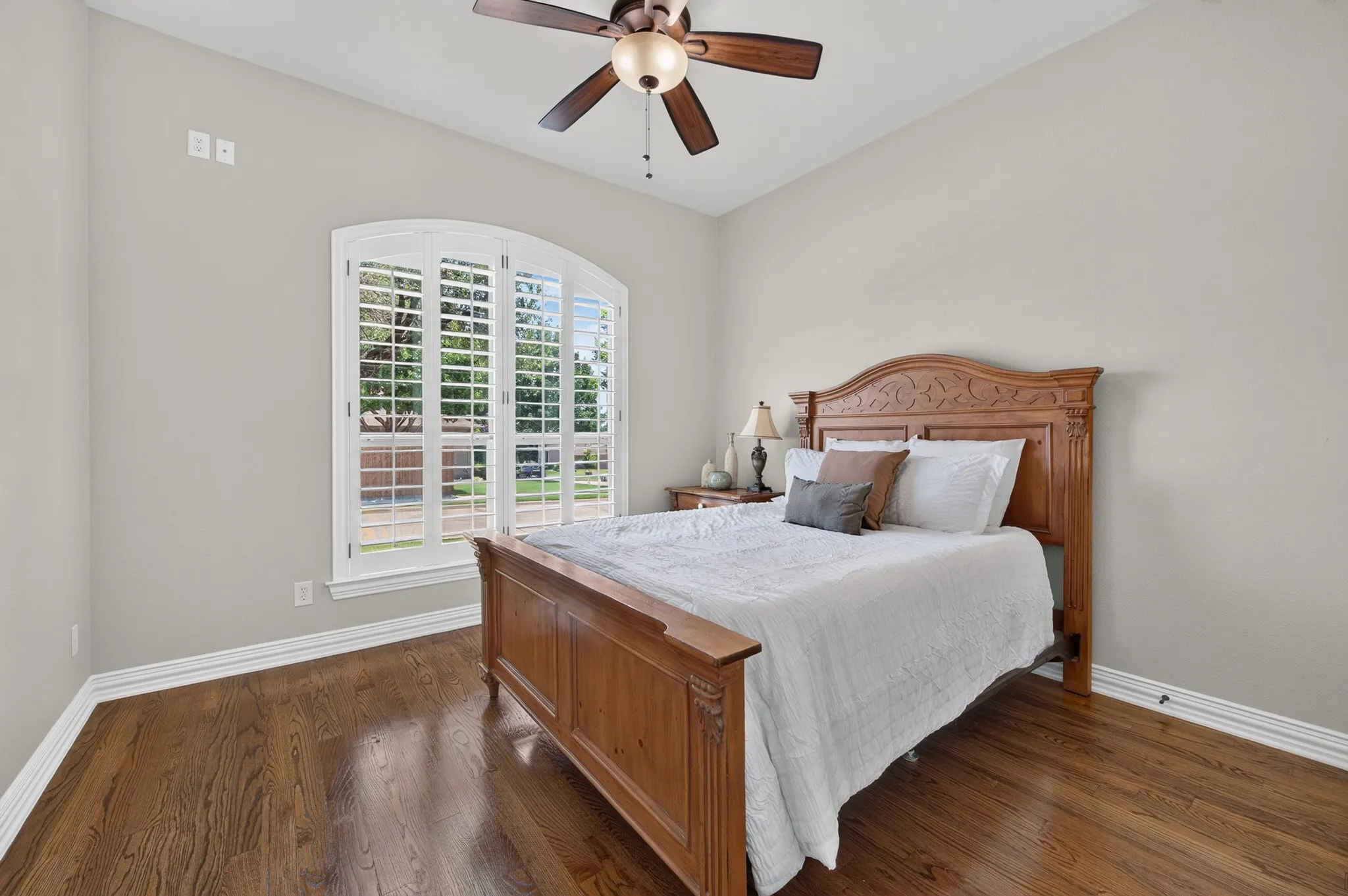 Secondary bedroom located downstairs .  Note the wood flooring and plantation shutters!