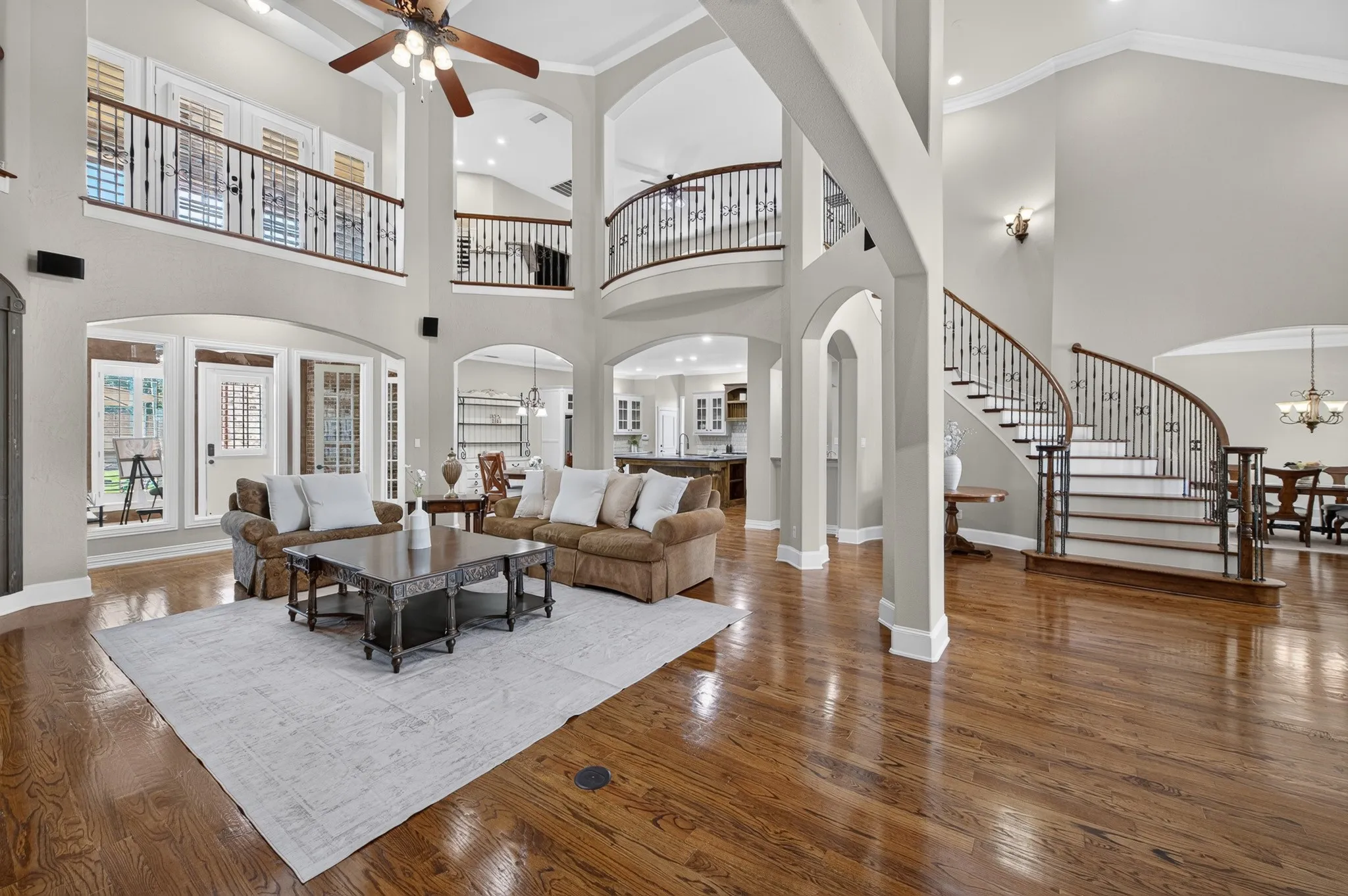 View of the open living room back to the kitchen with 2 story high ceiling and open space upstairs