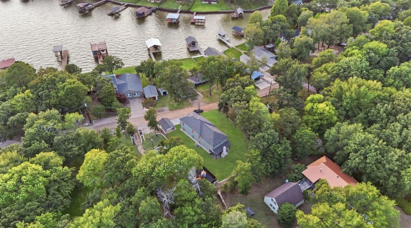 Aerial perspective showcasing a residential property with extensive surrounding greenery