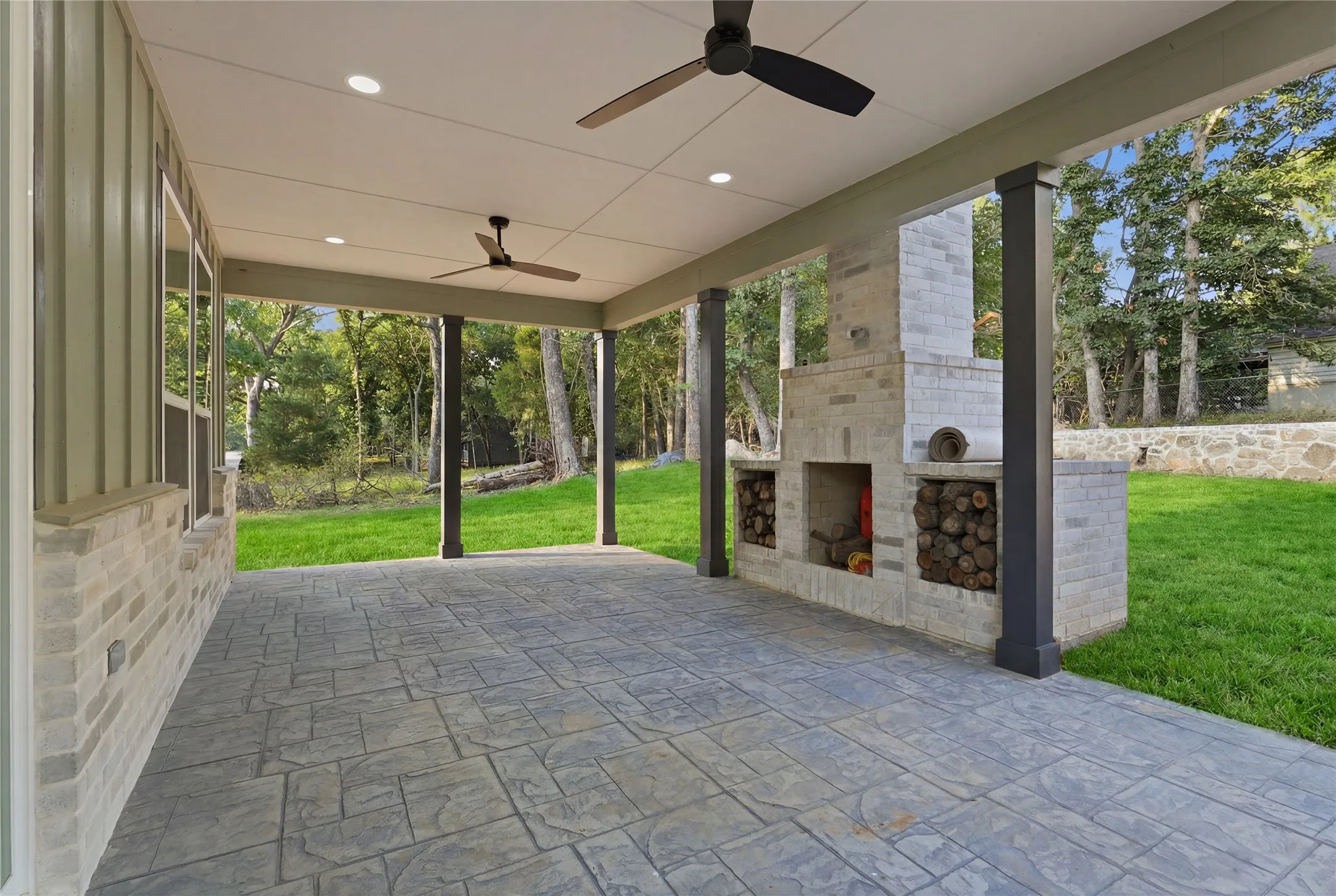 Covered balcony with wood-finish flooring, featuring a modern ceiling fan and cable railings