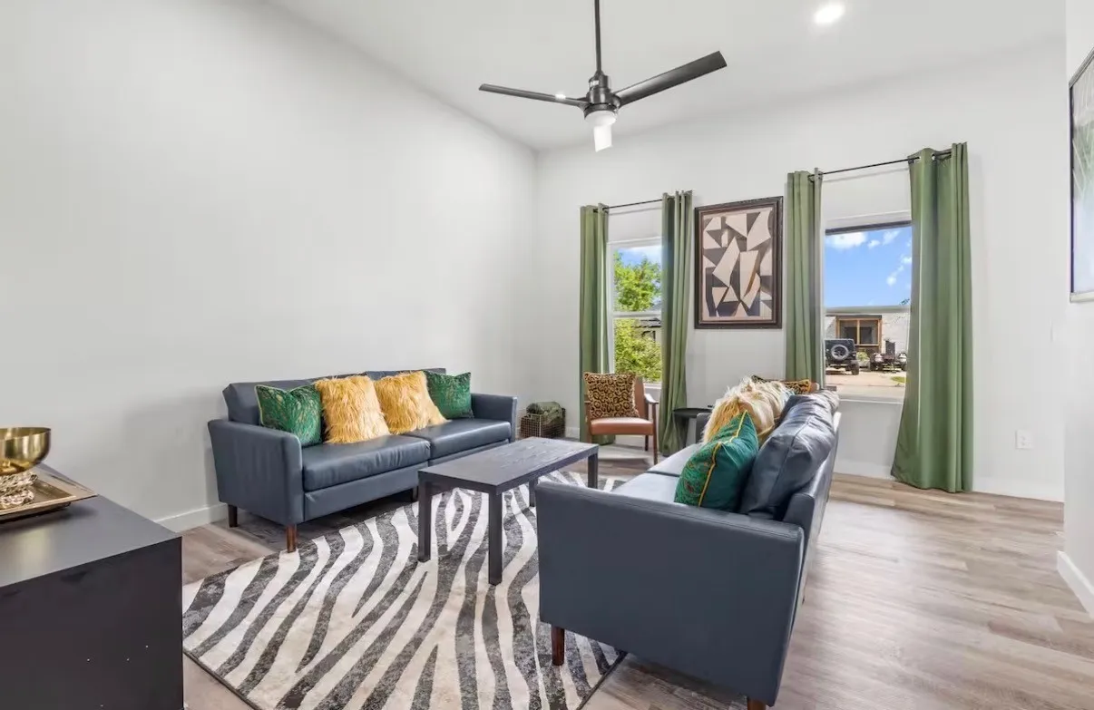Vaulted ceiling living area featuring wood-finish flooring, recessed lighting, and a contemporary ceiling fan