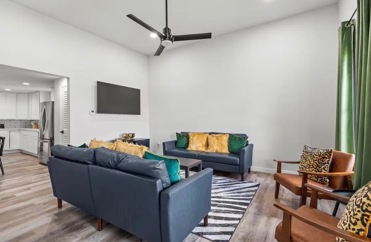 Living area featuring vaulted ceilings, wood-finish flooring, a contemporary ceiling fan, and recessed lighting