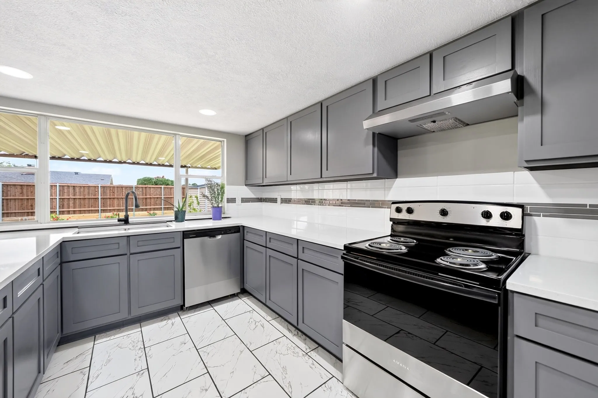 Modern kitchen featuring gray cabinetry and white countertops
