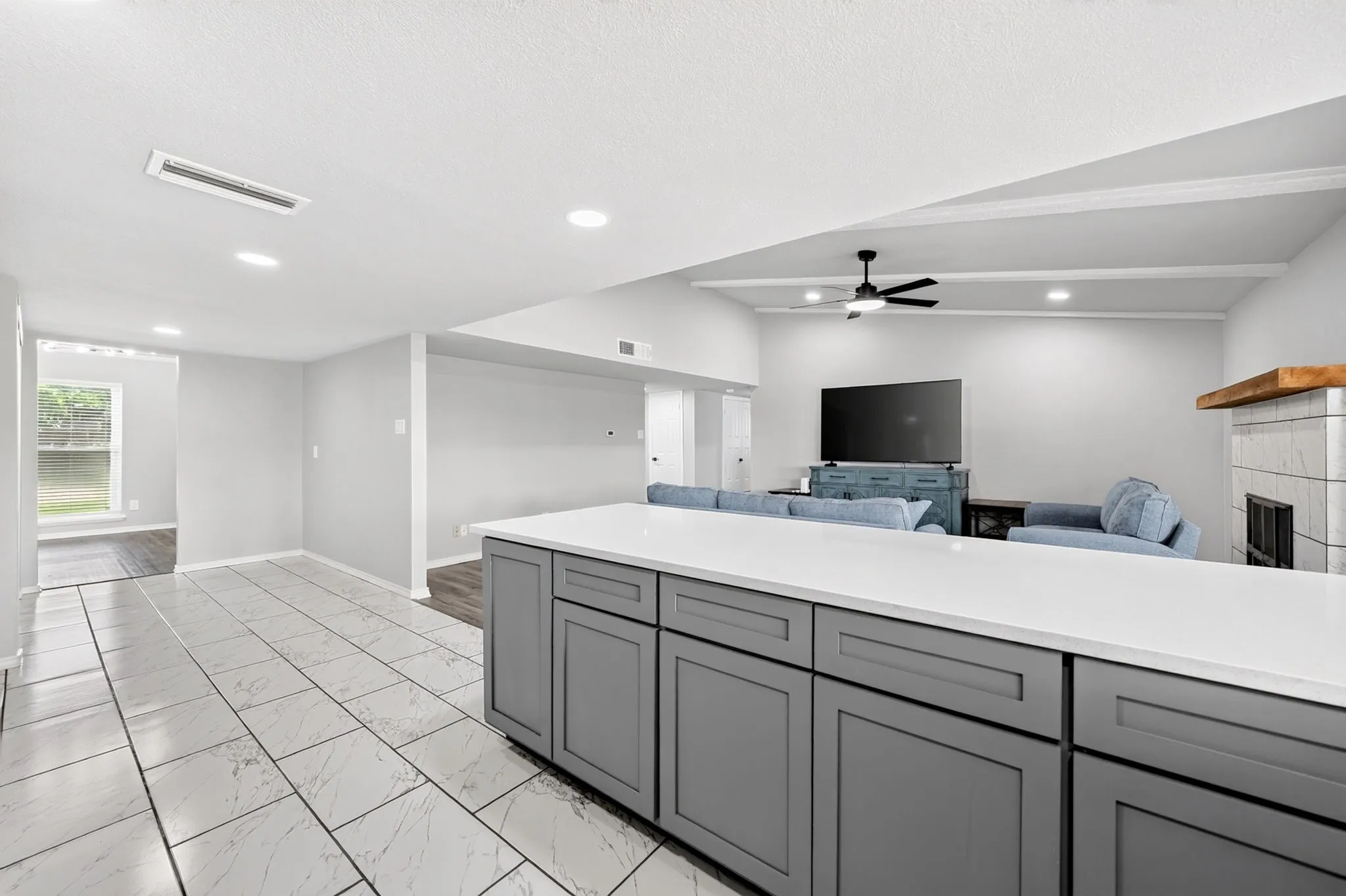 Kitchen island with gray cabinetry and light-colored countertop