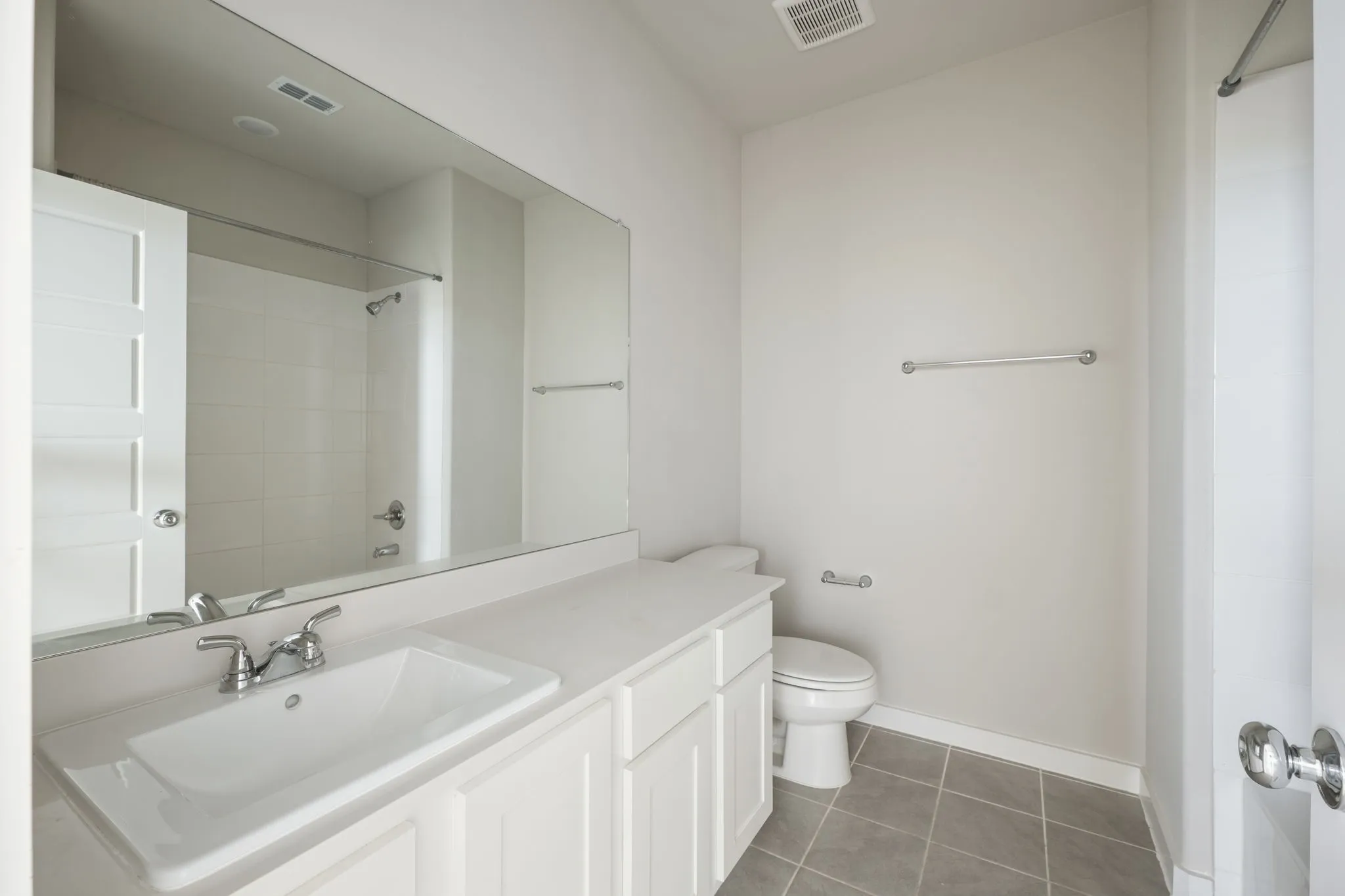 Bathroom featuring a large vanity with white cabinetry, an integrated sink, and a coordinating countertop