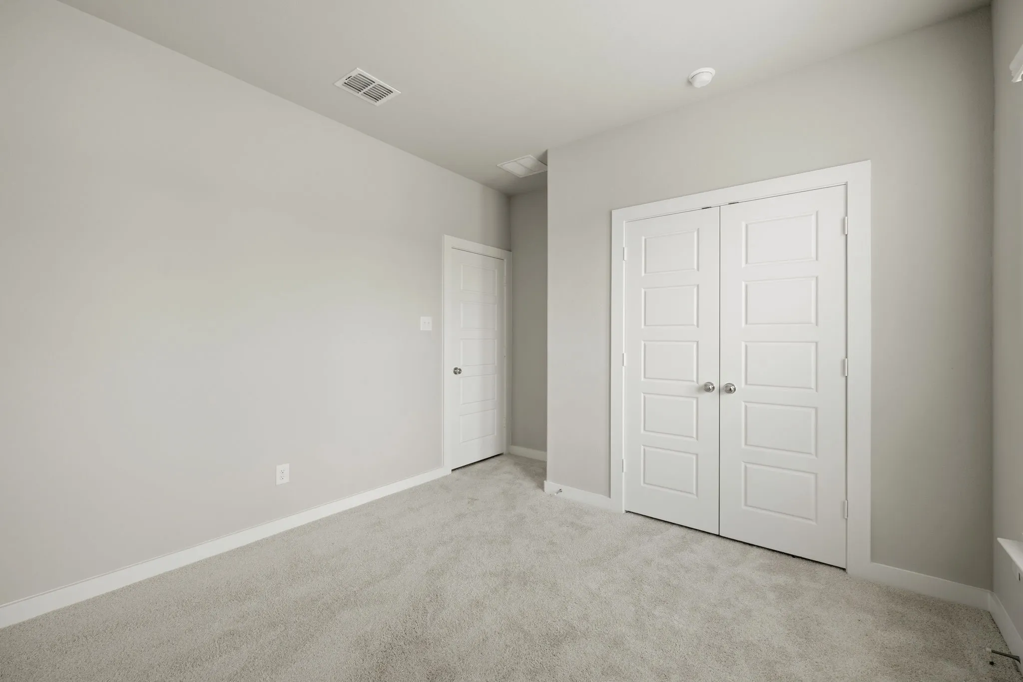 Open interior space featuring light gray wall paint and light gray carpeting
