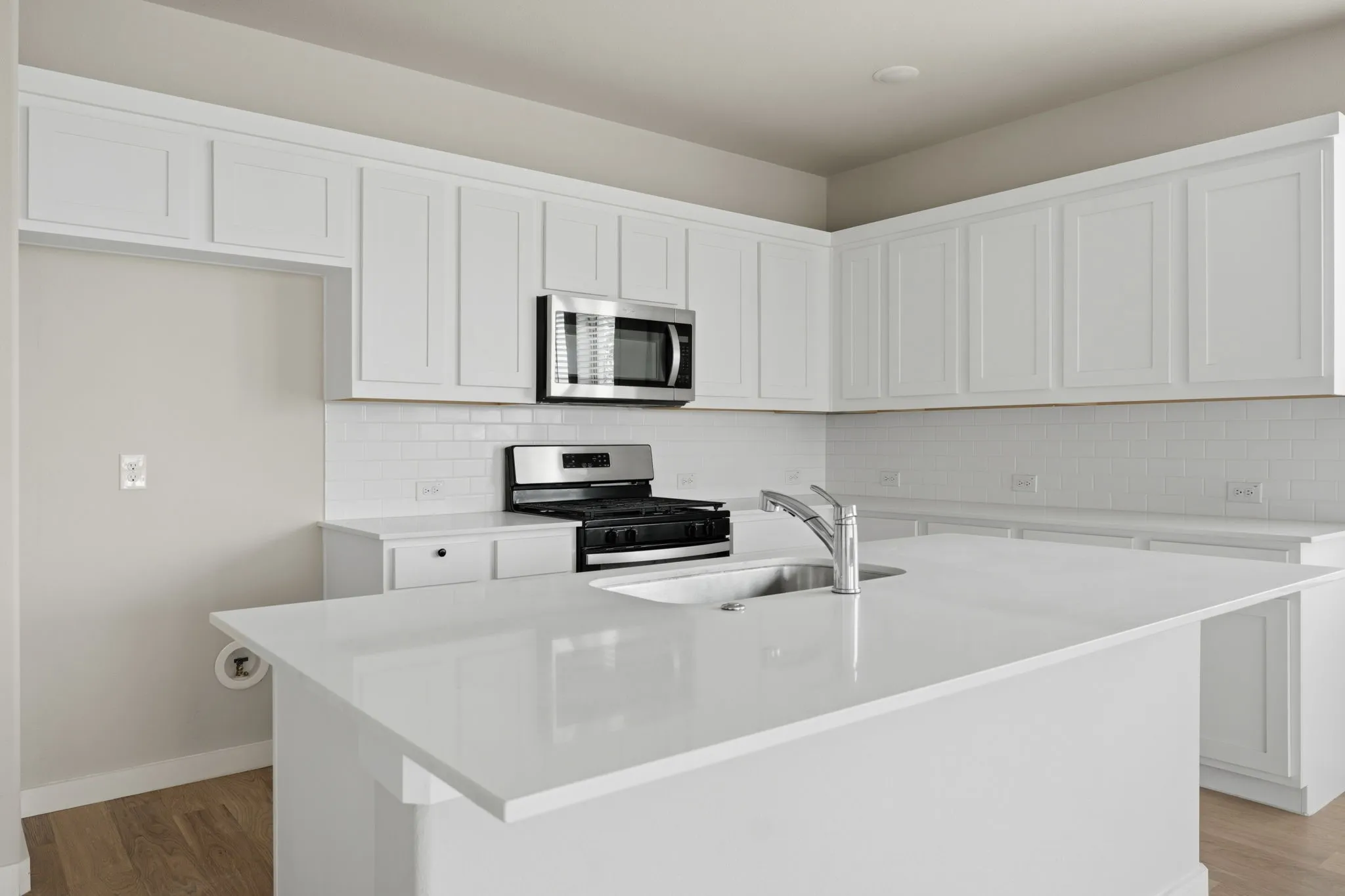Kitchen featuring a large central island with an undermount sink and gooseneck faucet
