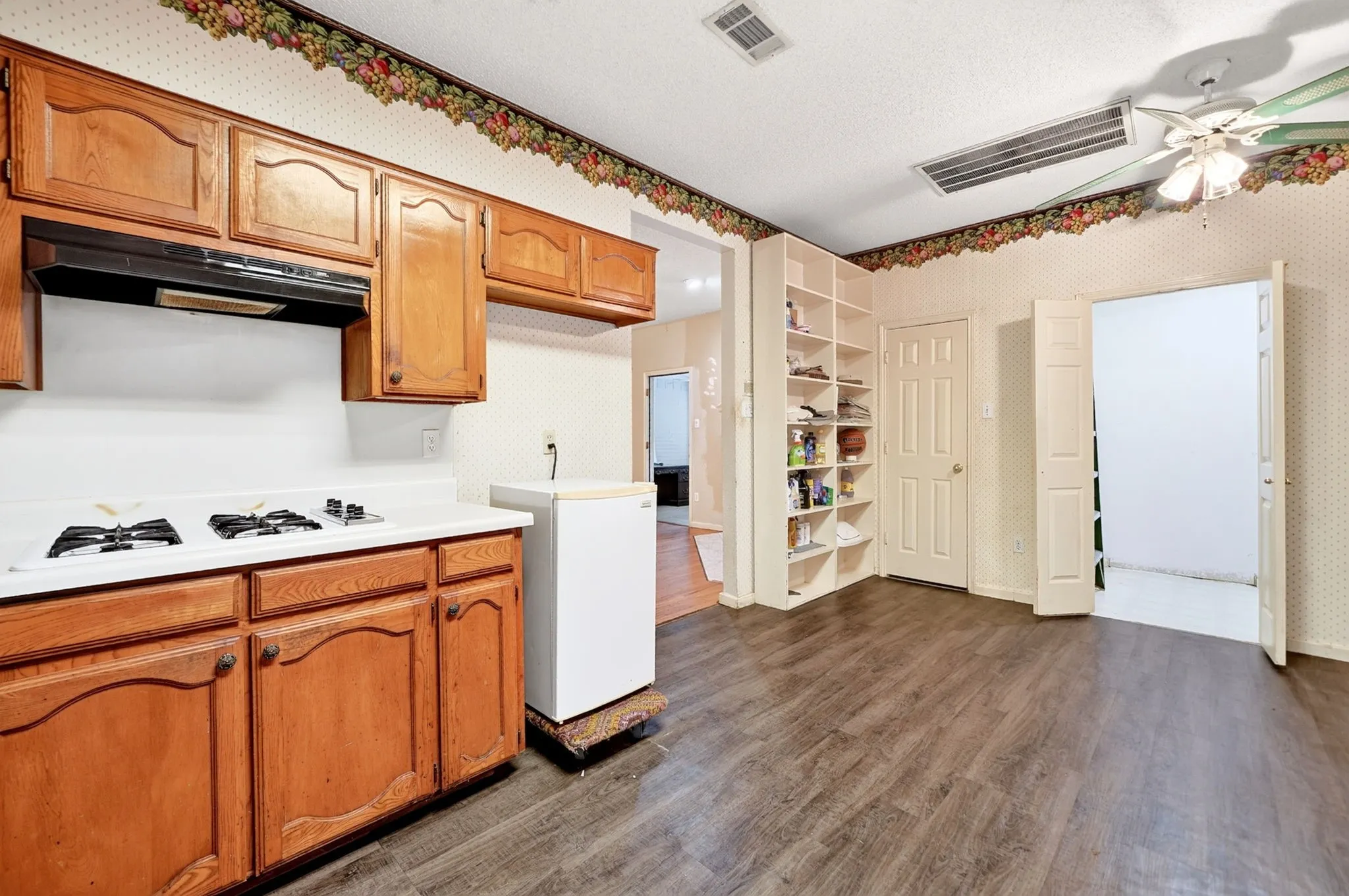 Kitchen space featuring wood-finish flooring and built-in shelving