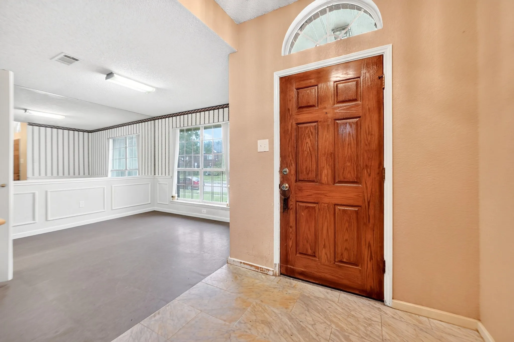 Entryway featuring a paneled wood door with an arched transom window