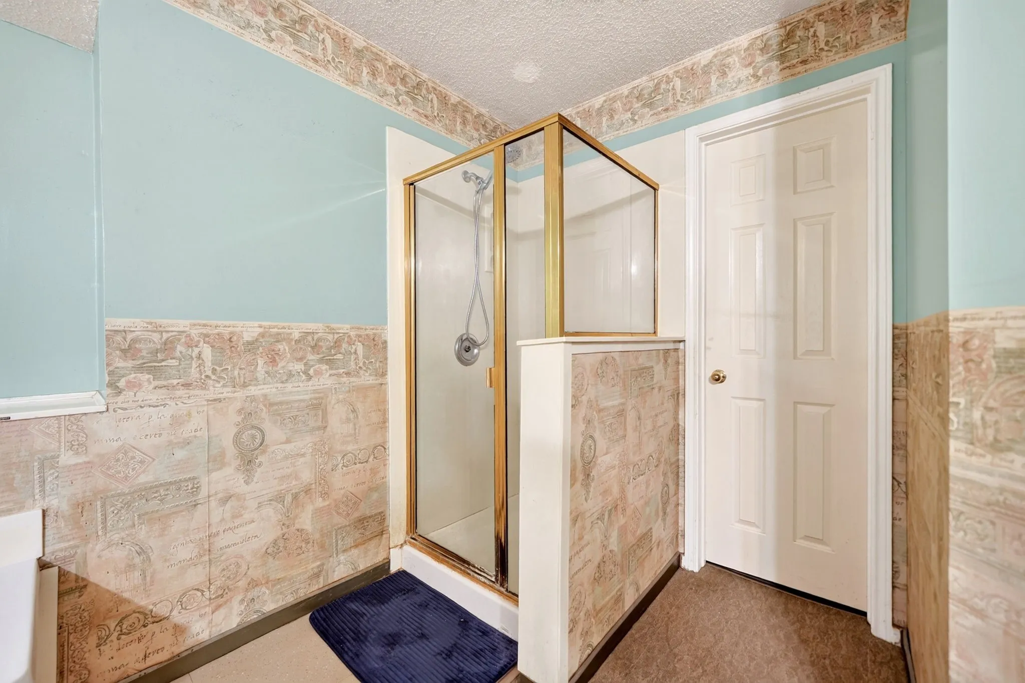 Enclosed shower with brass-finish framing and clear glass panels