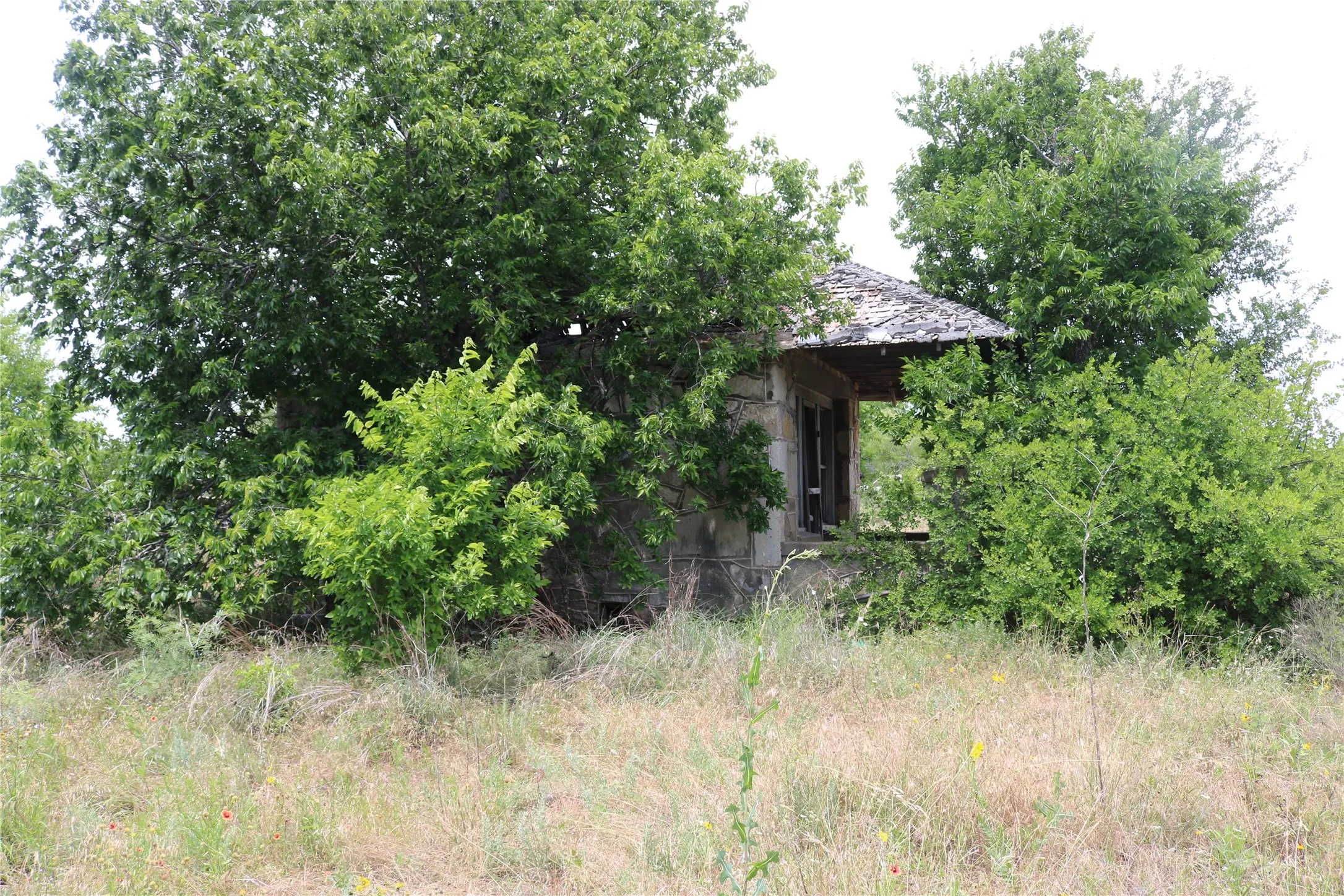 Side view of smaller rock structure as seen from SH 6. Porch on front of building.