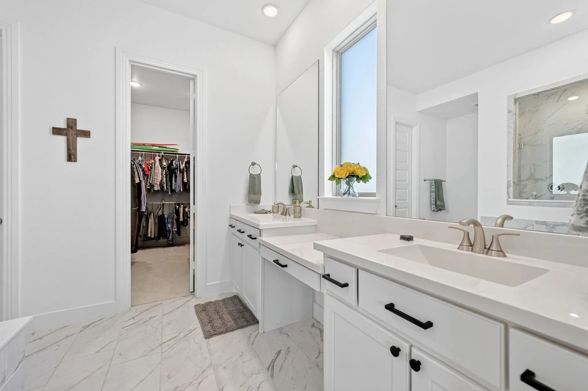 Dual vanity with integrated sinks, white cabinetry, and matte black hardware