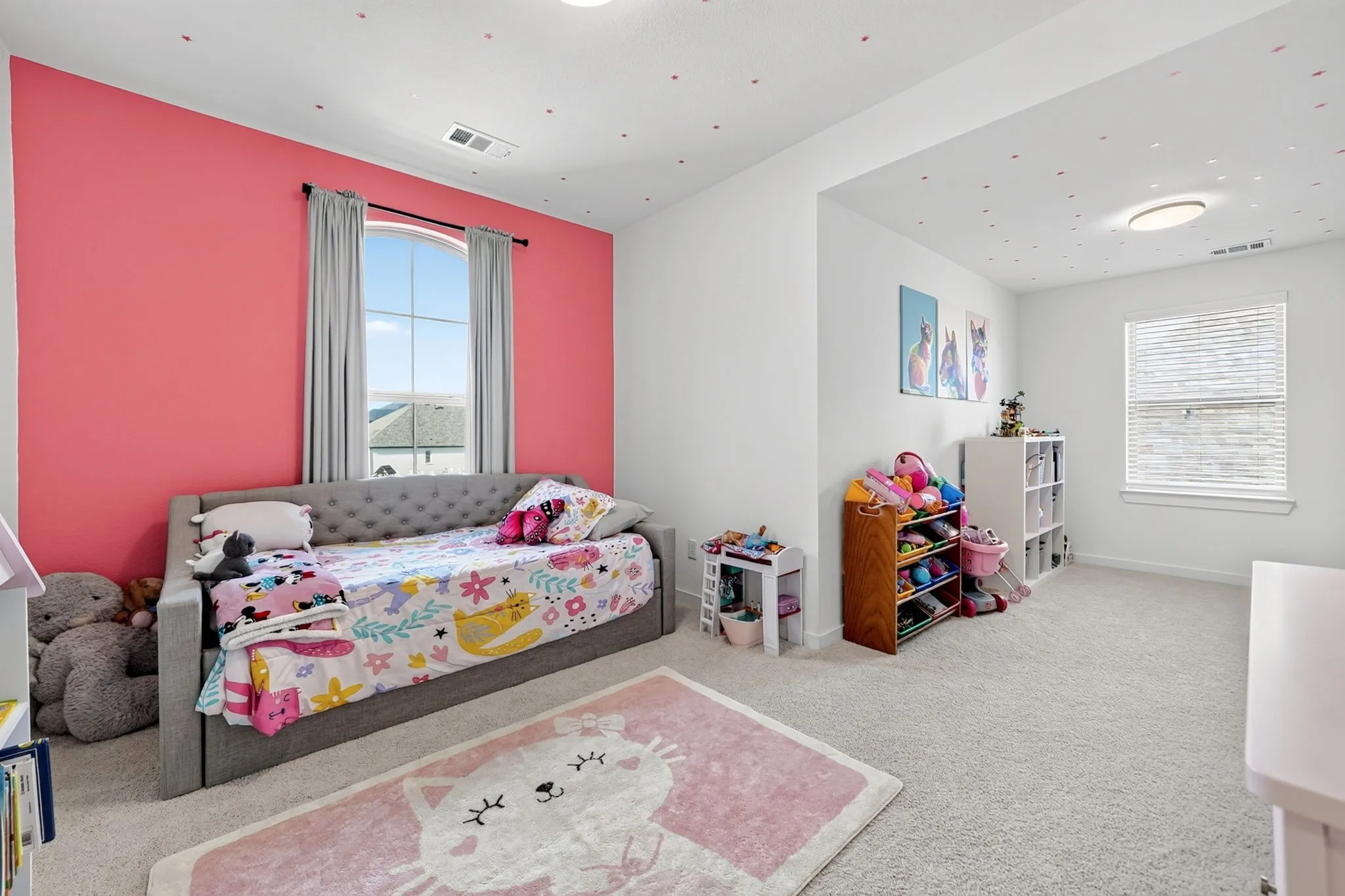 Carpeted interior room featuring a large arched window with curtains, a secondary window with blinds, and recessed lighting