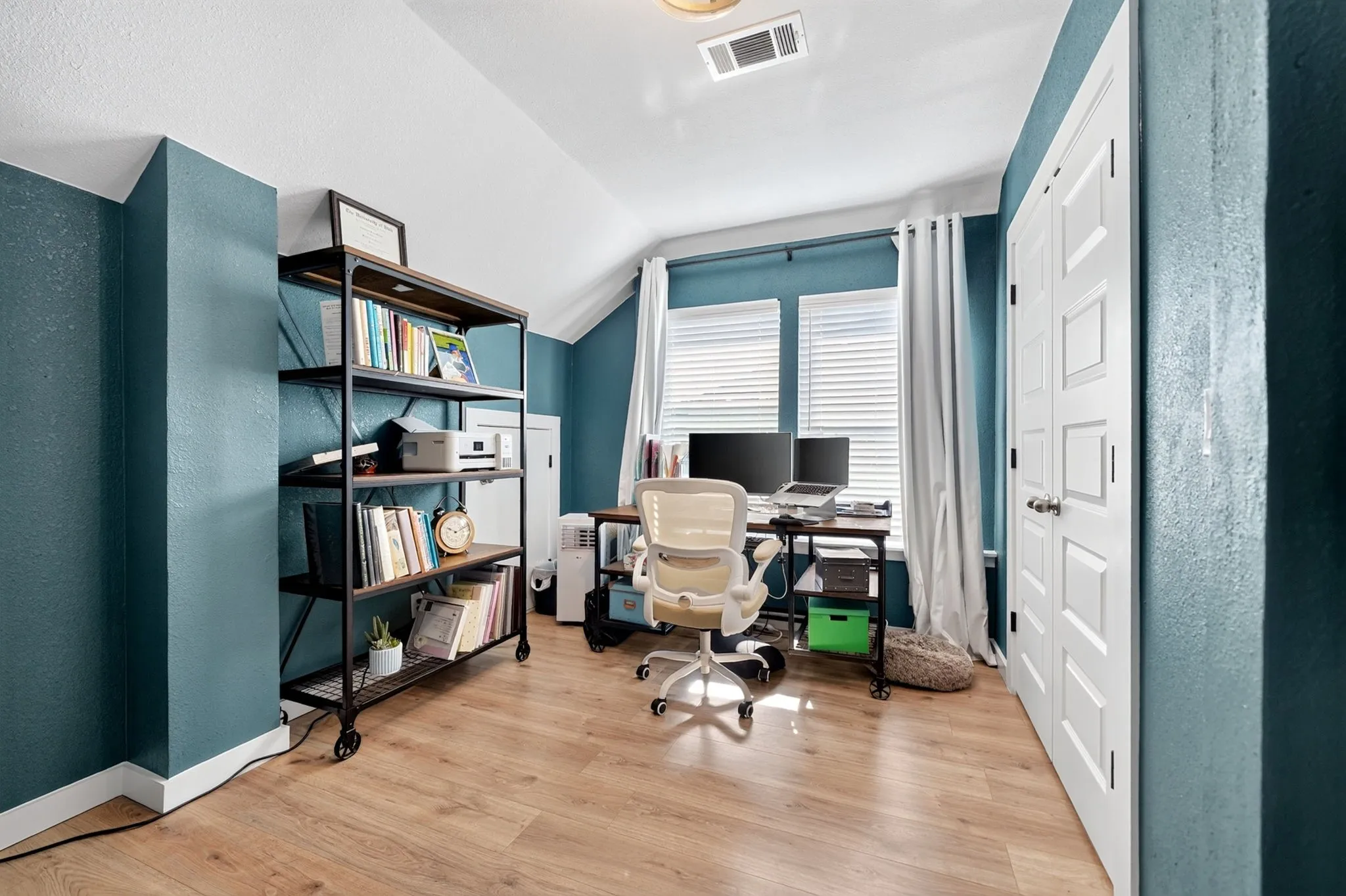 Interior room featuring wood-finish flooring, white baseboards, and blue-painted walls
