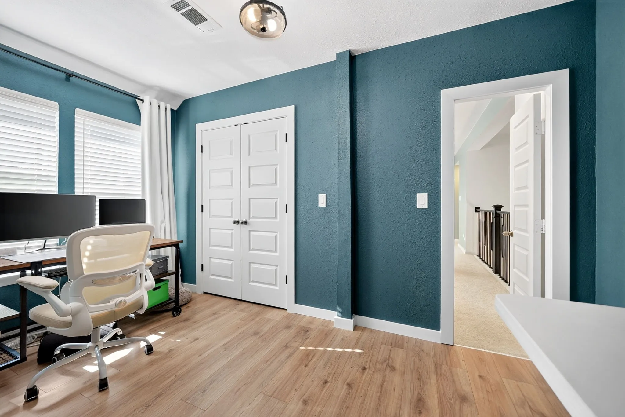 Room featuring wood-finish flooring and a bright blue accent wall