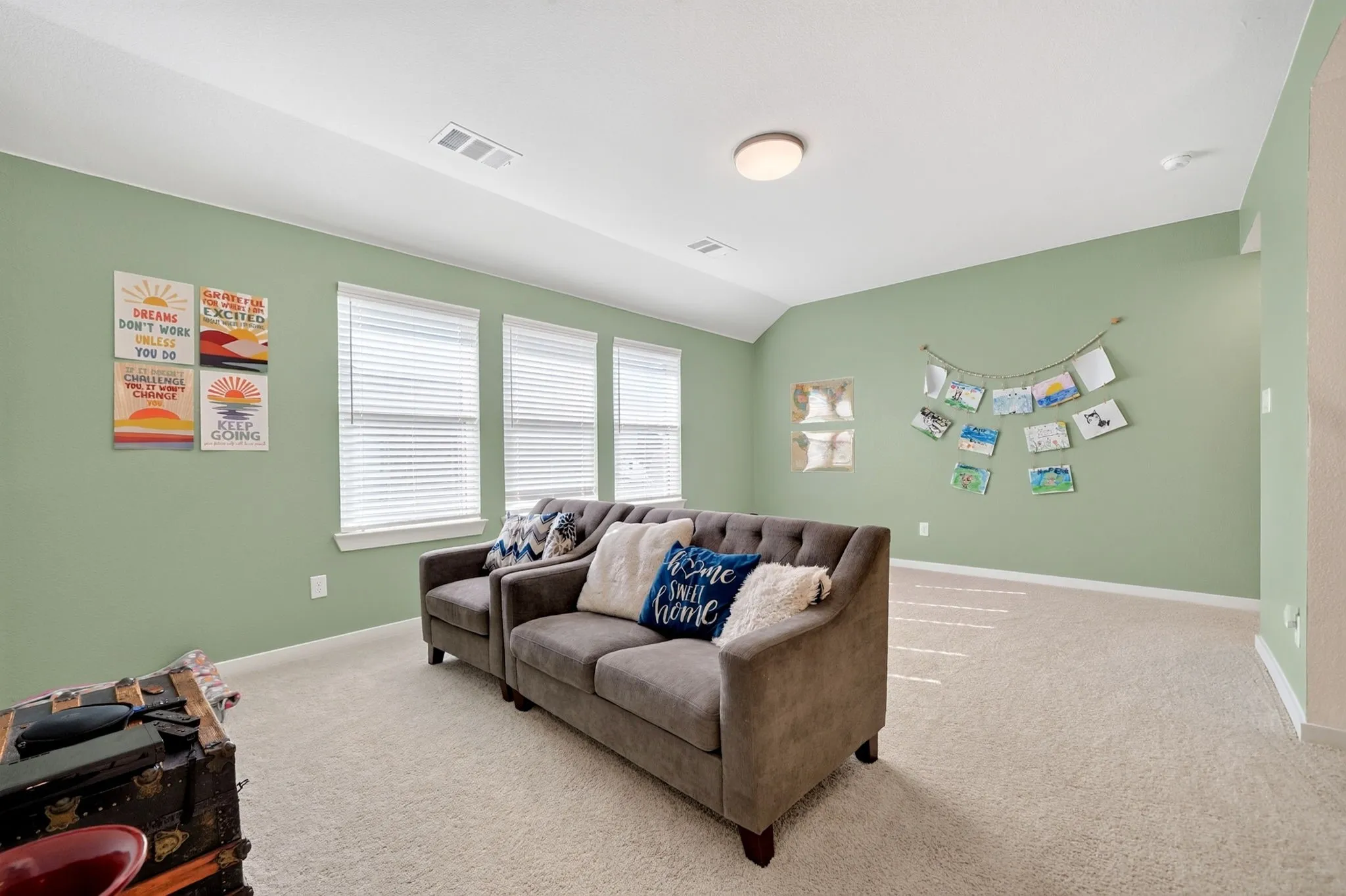 Carpeted room with light green walls, a white ceiling, and three windows featuring white blinds