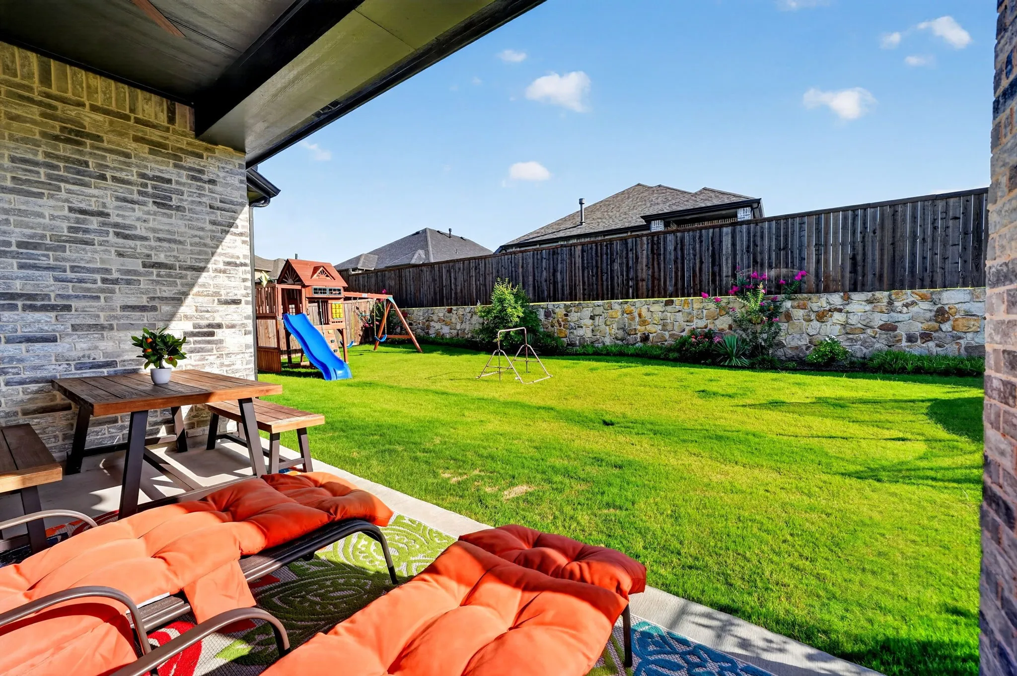 Covered patio featuring a wood-finish picnic table and seating area