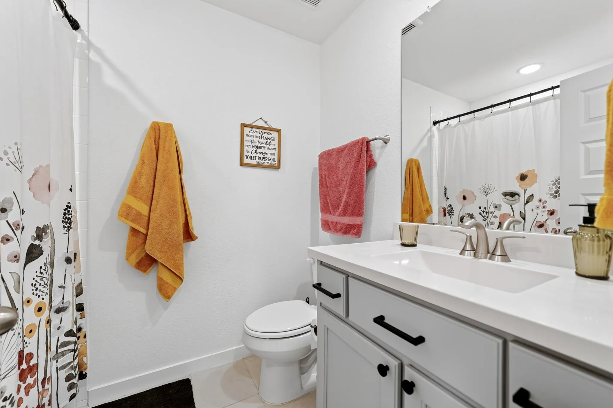 Bathroom featuring a single vanity with a white countertop, undermount sink, and brushed nickel faucet