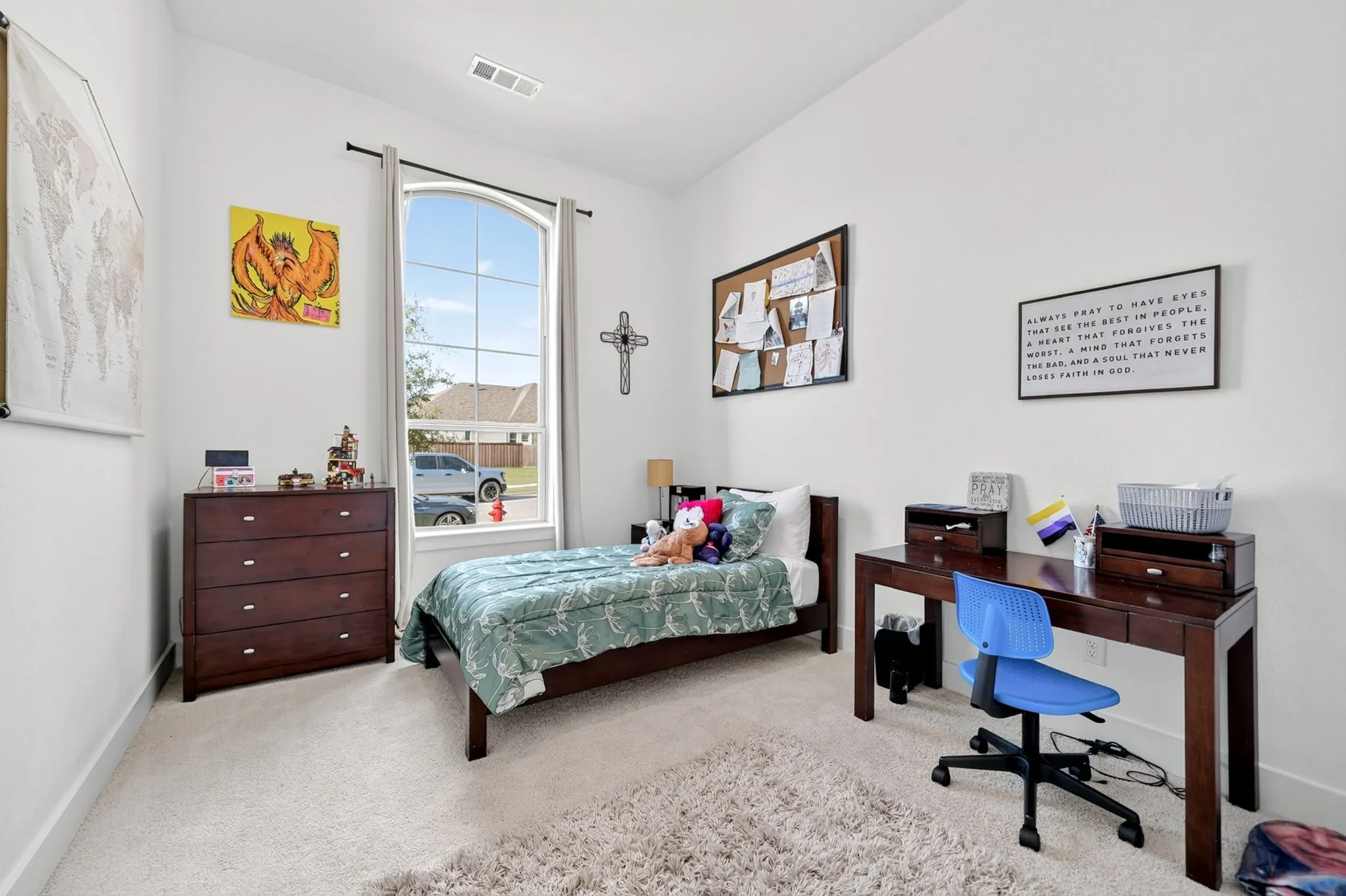 Room featuring a large arched window with natural light, light-toned carpeting, high ceilings, and white wall finishes