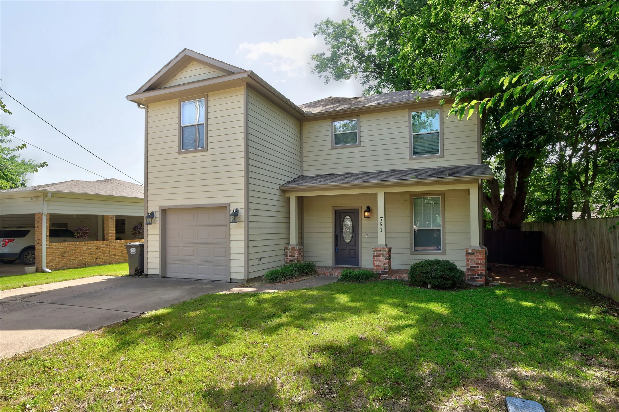 Contemporary two-story exterior featuring light-colored siding and a covered front porch
