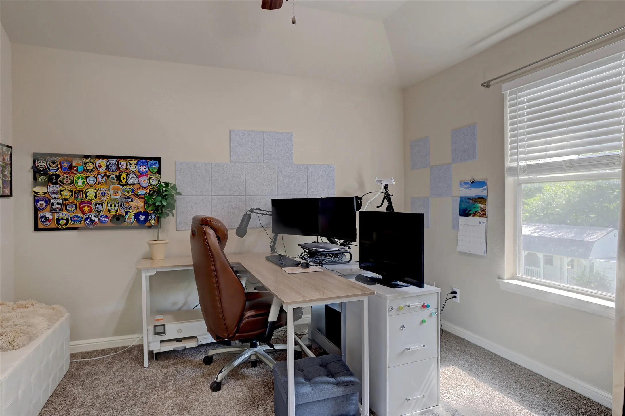 Neutral-toned walls with vaulted ceiling and ceiling fan
