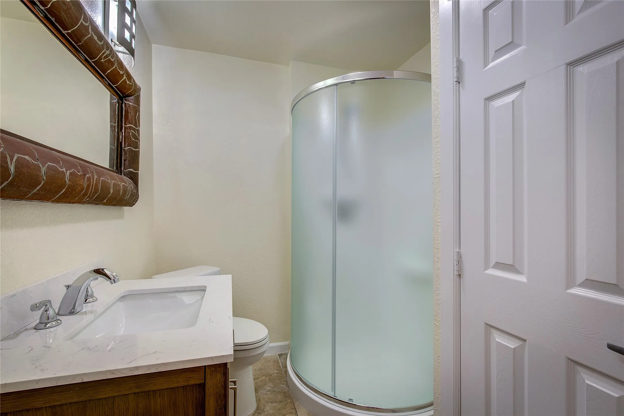Secondary bathroom with quartz countertops and designer shower