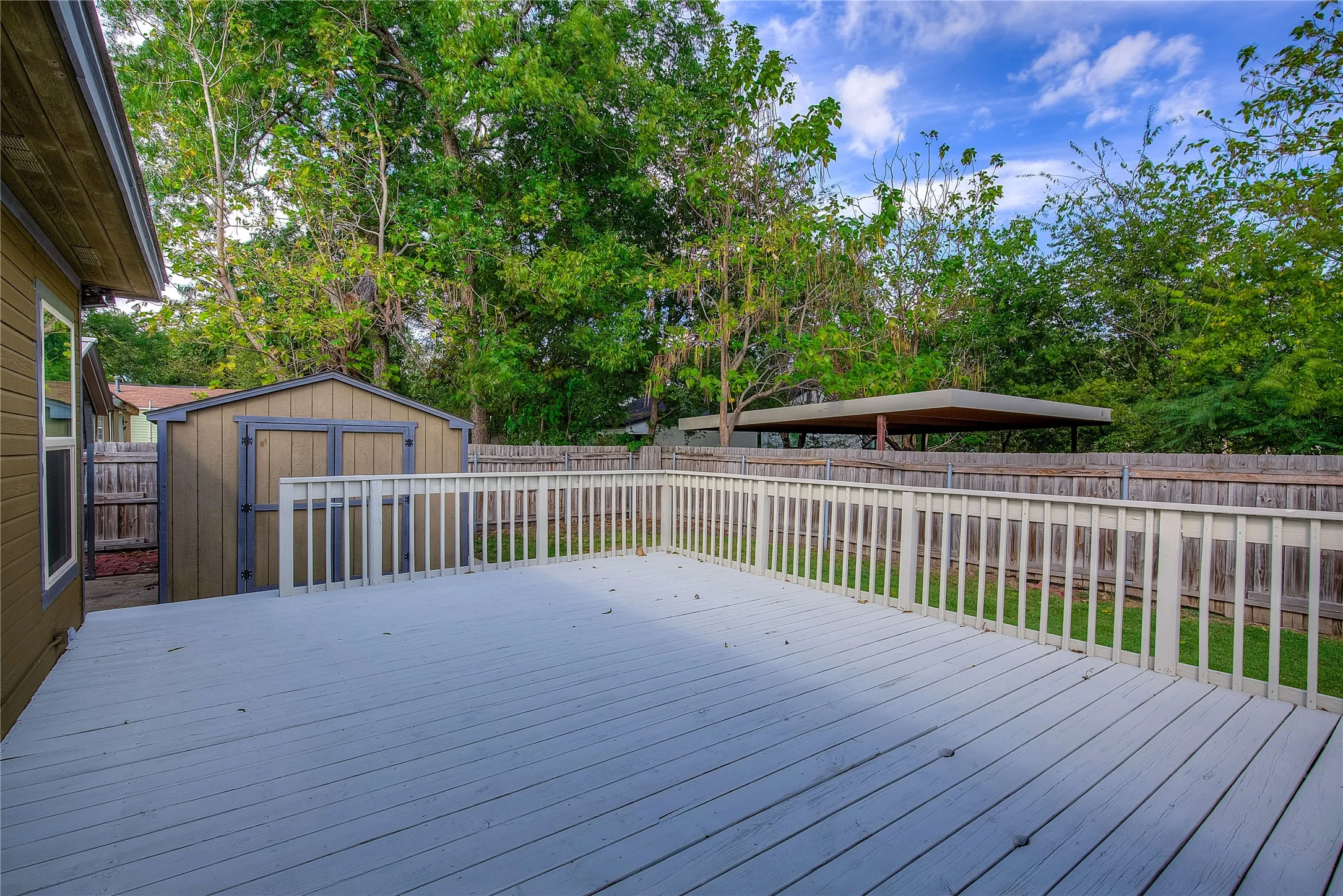 18x24 wood deck with railing and privacy fencing.  Note the storage building.
