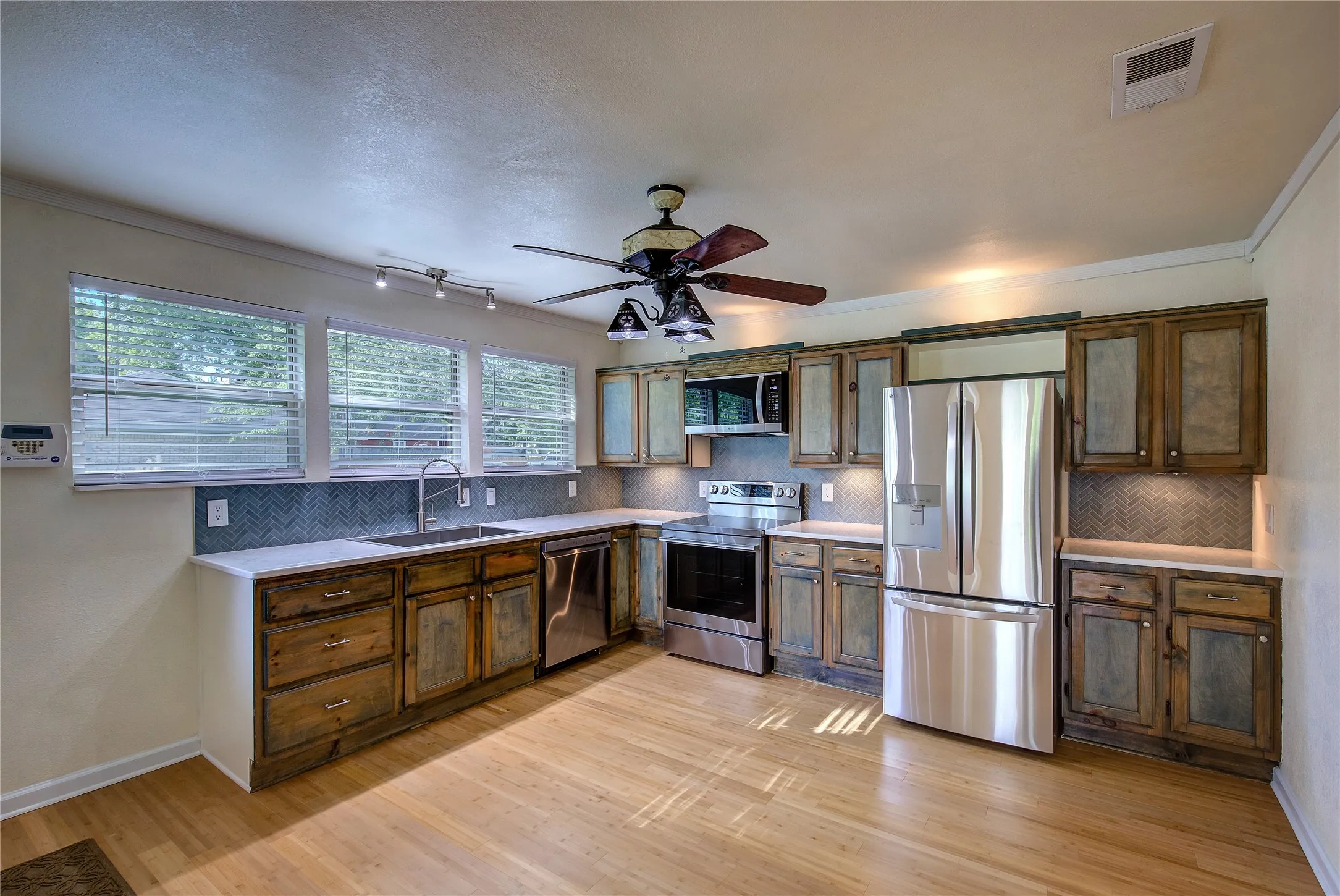 Totally updated kitchen offers all new appliances, cabinetry, quartz countertops and tile backsplash and bamboo flooring.  Note the designer fan/lights.