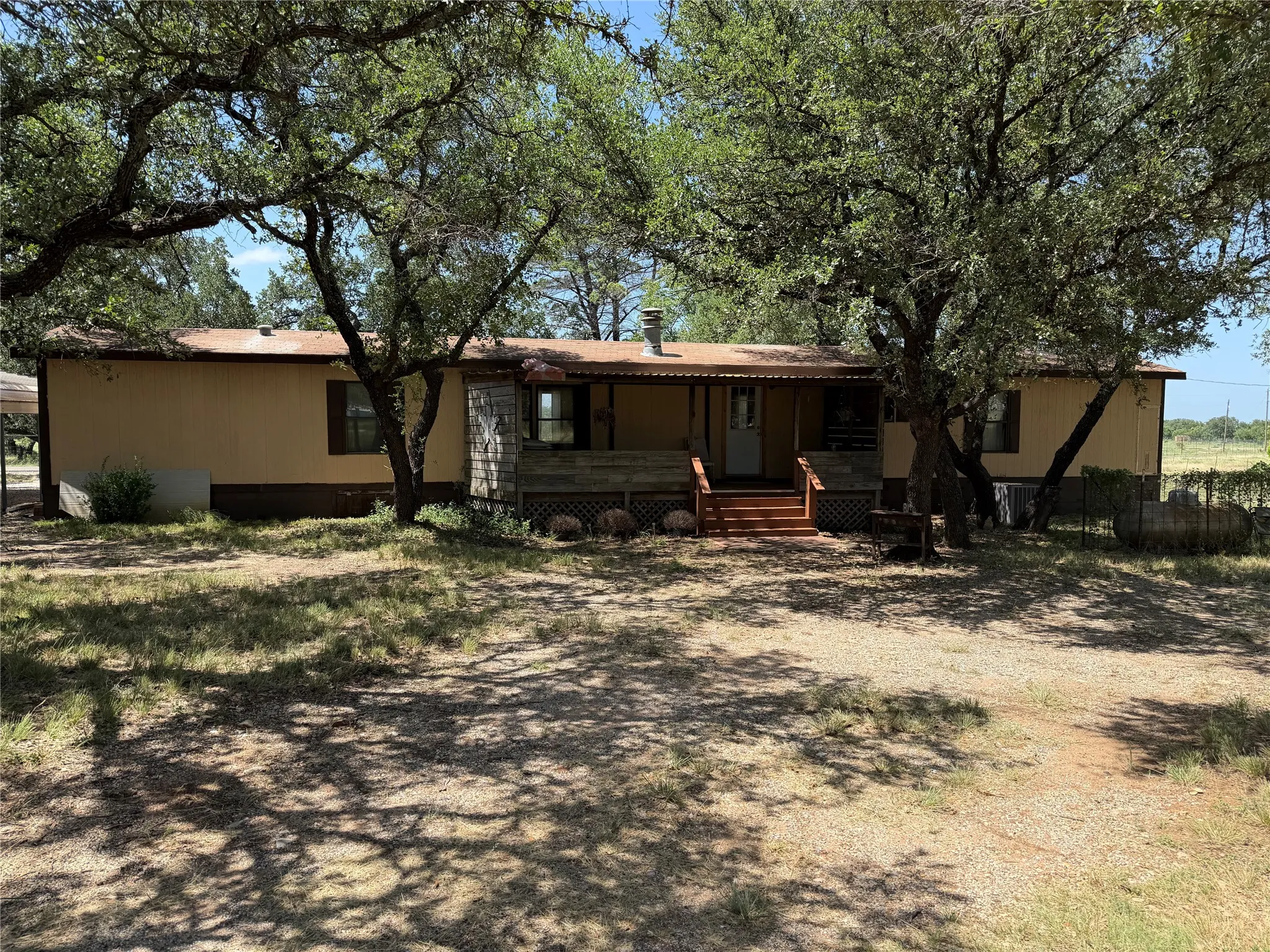 Single-story residence featuring a covered front porch, wood porch railings, and exterior siding