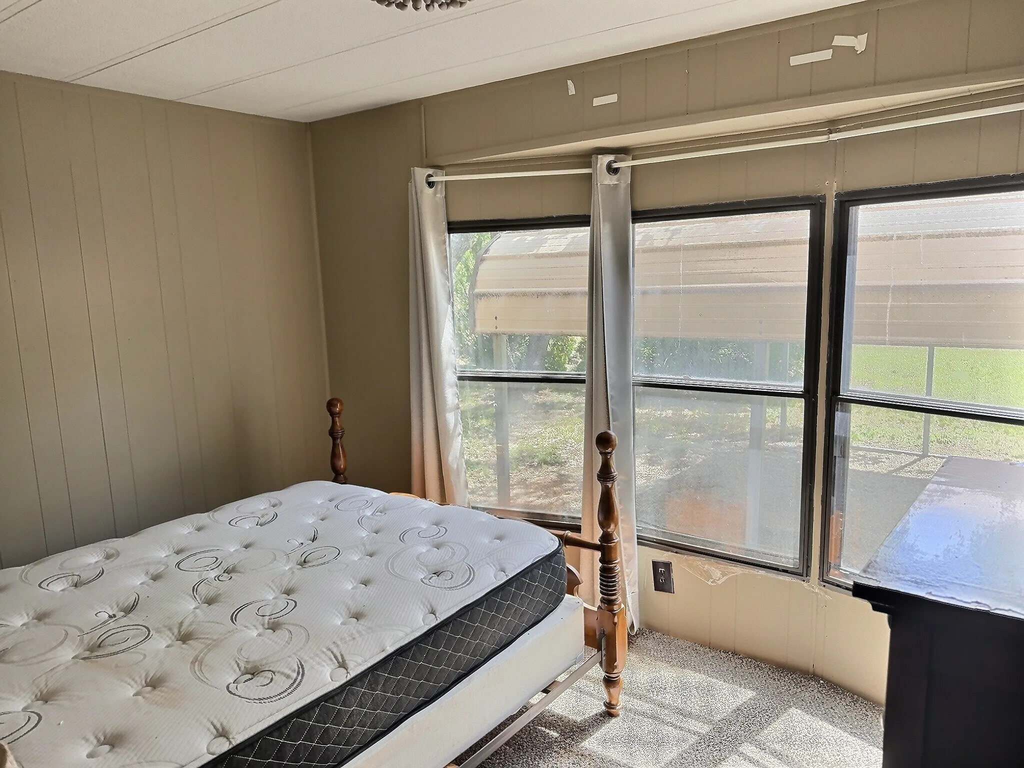Room featuring three large windows with curtains, providing natural light