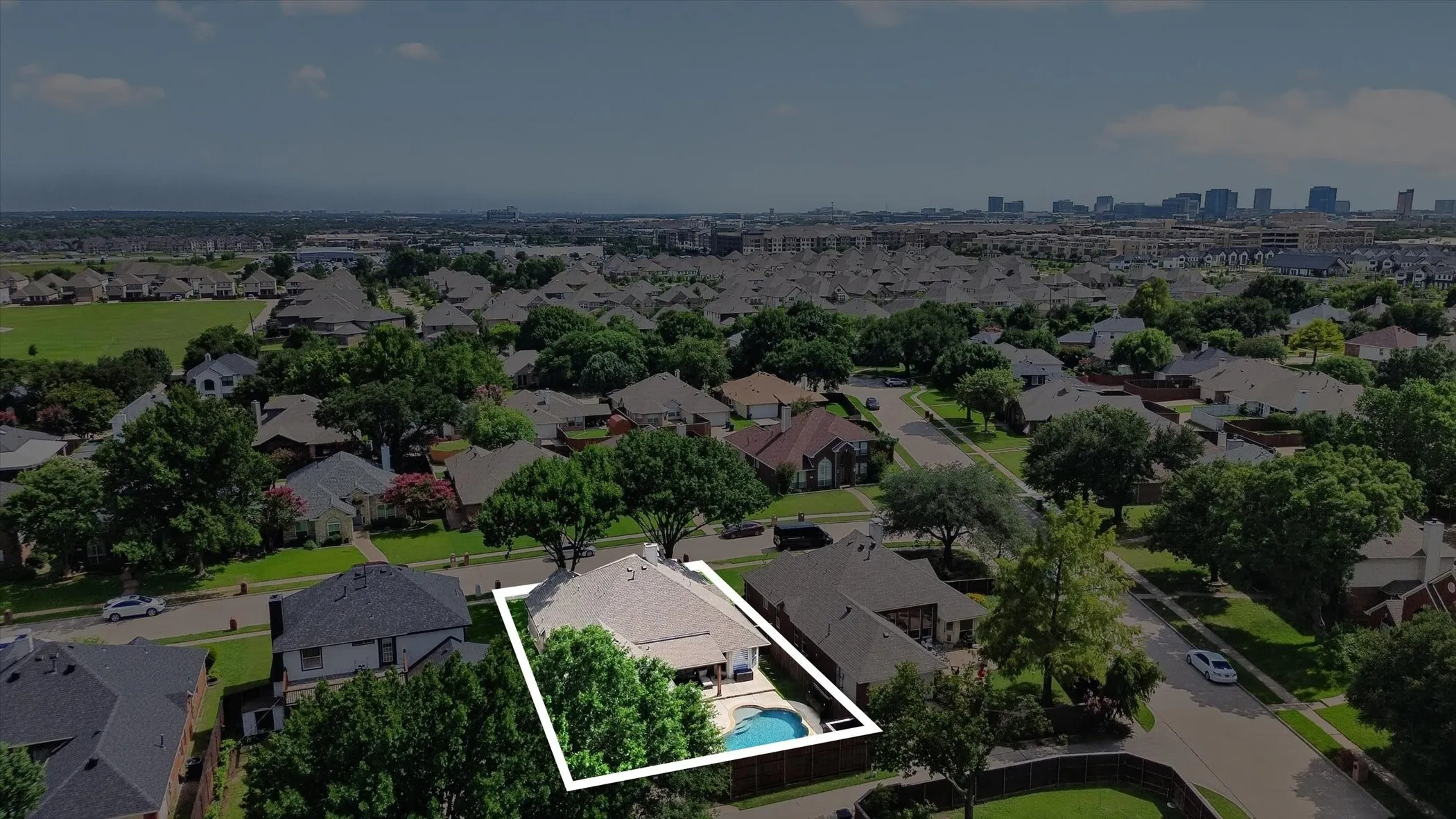 Aerial view highlighting the property with an in-ground swimming pool and surrounding mature trees