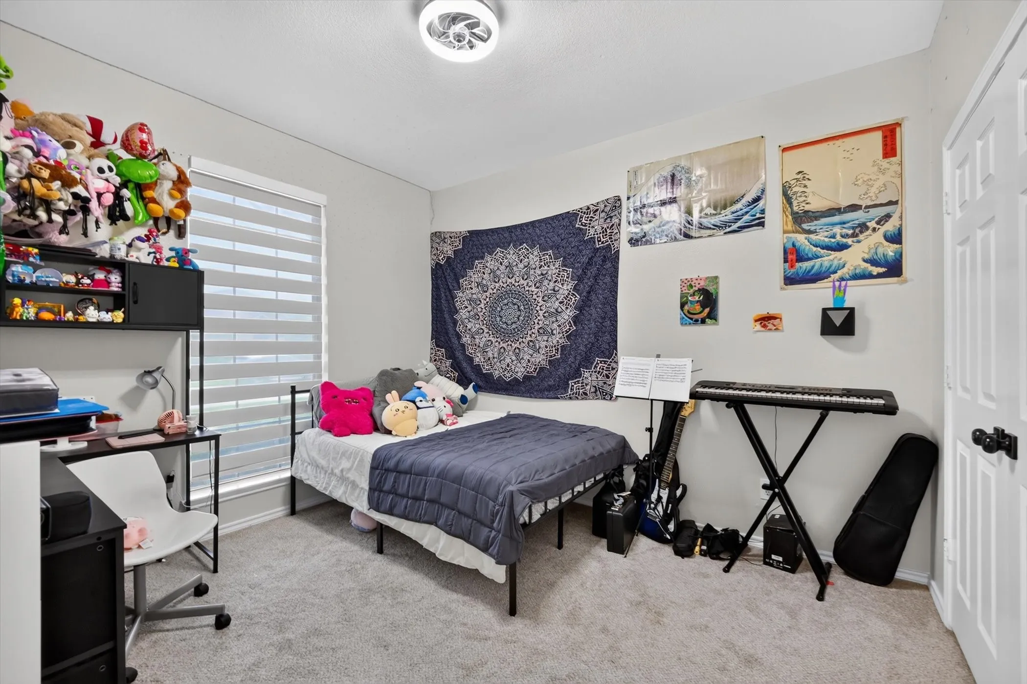 Carpeted room with a ceiling-mounted light fixture, white walls, and a window with horizontal blinds