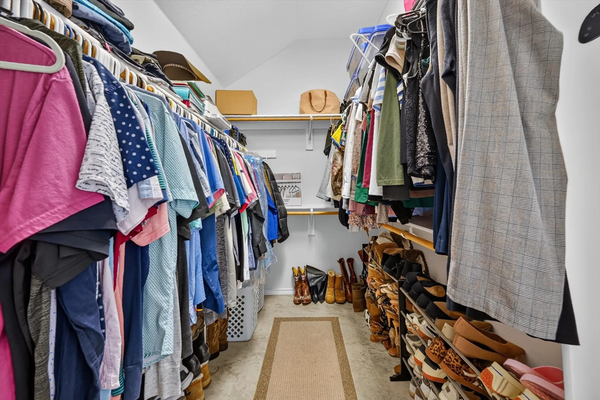 Walk-in closet featuring extensive built-in shelving, multiple hanging rods, durable flooring, and recessed lighting