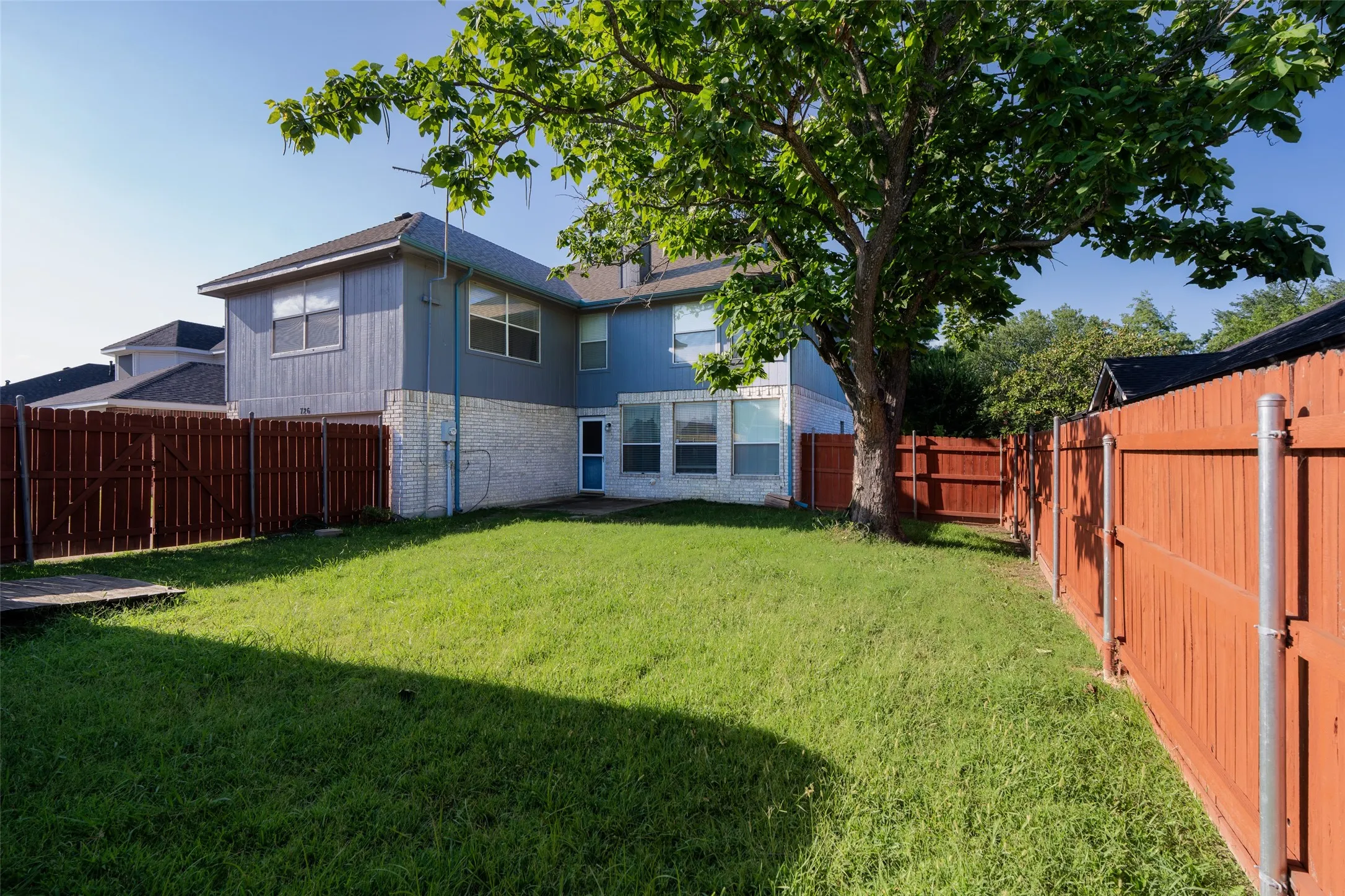 Spacious, fully fenced backyard with a mature shade tree and plenty of room to play, garden, or entertain