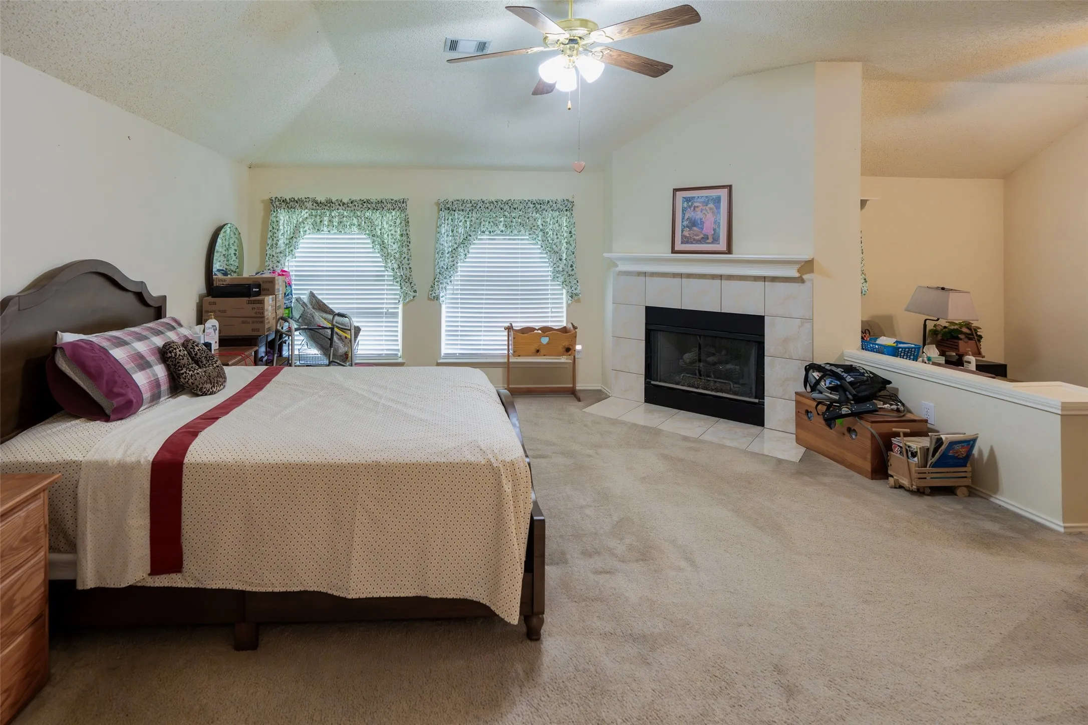 Raised primary bedroom with vaulted ceilings, cozy fireplace and plenty of room for oversized furniture