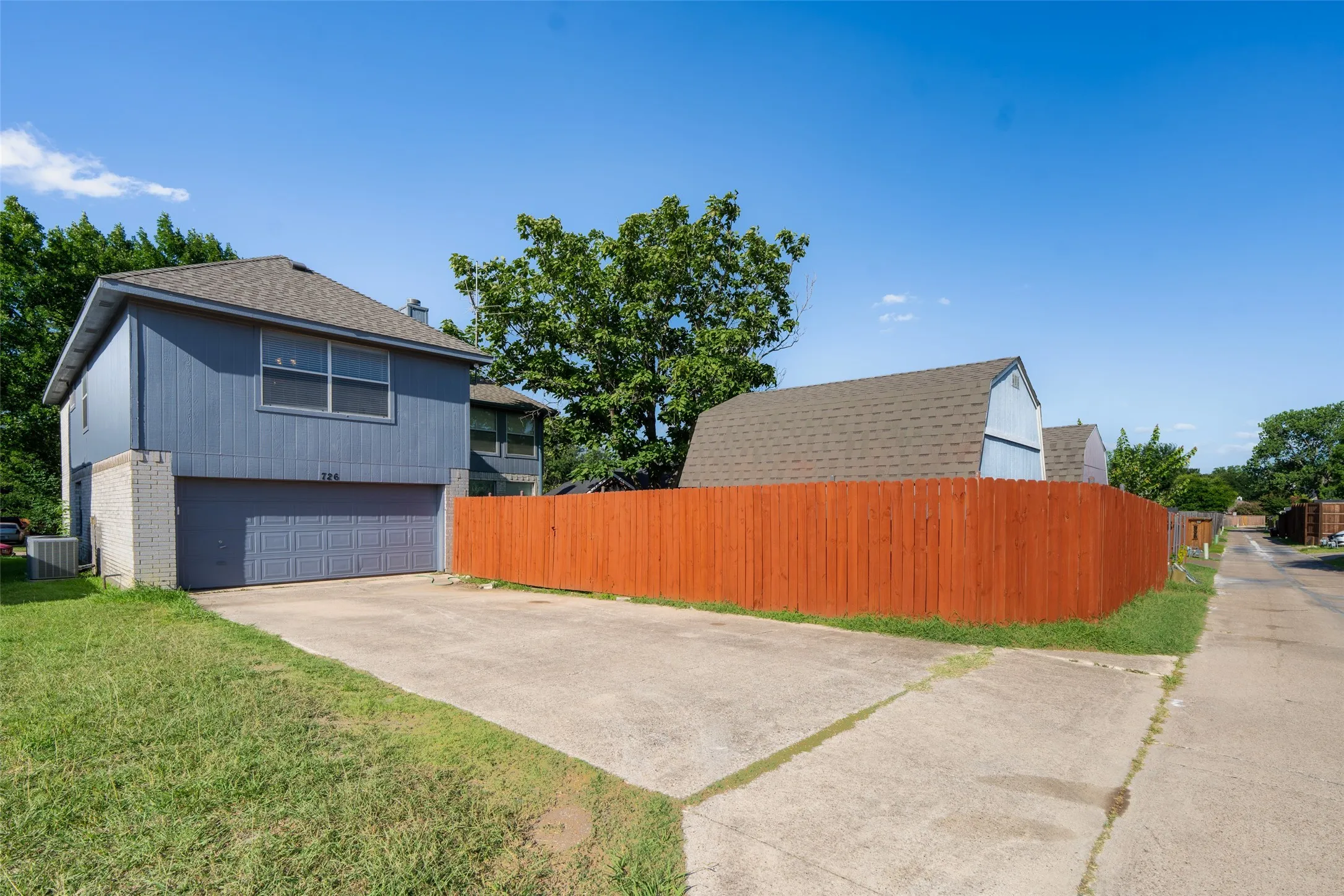 Rear-entry garage, extended driveway, fresh privacy fence, and two spacious storage buildings provide exceptional functionality