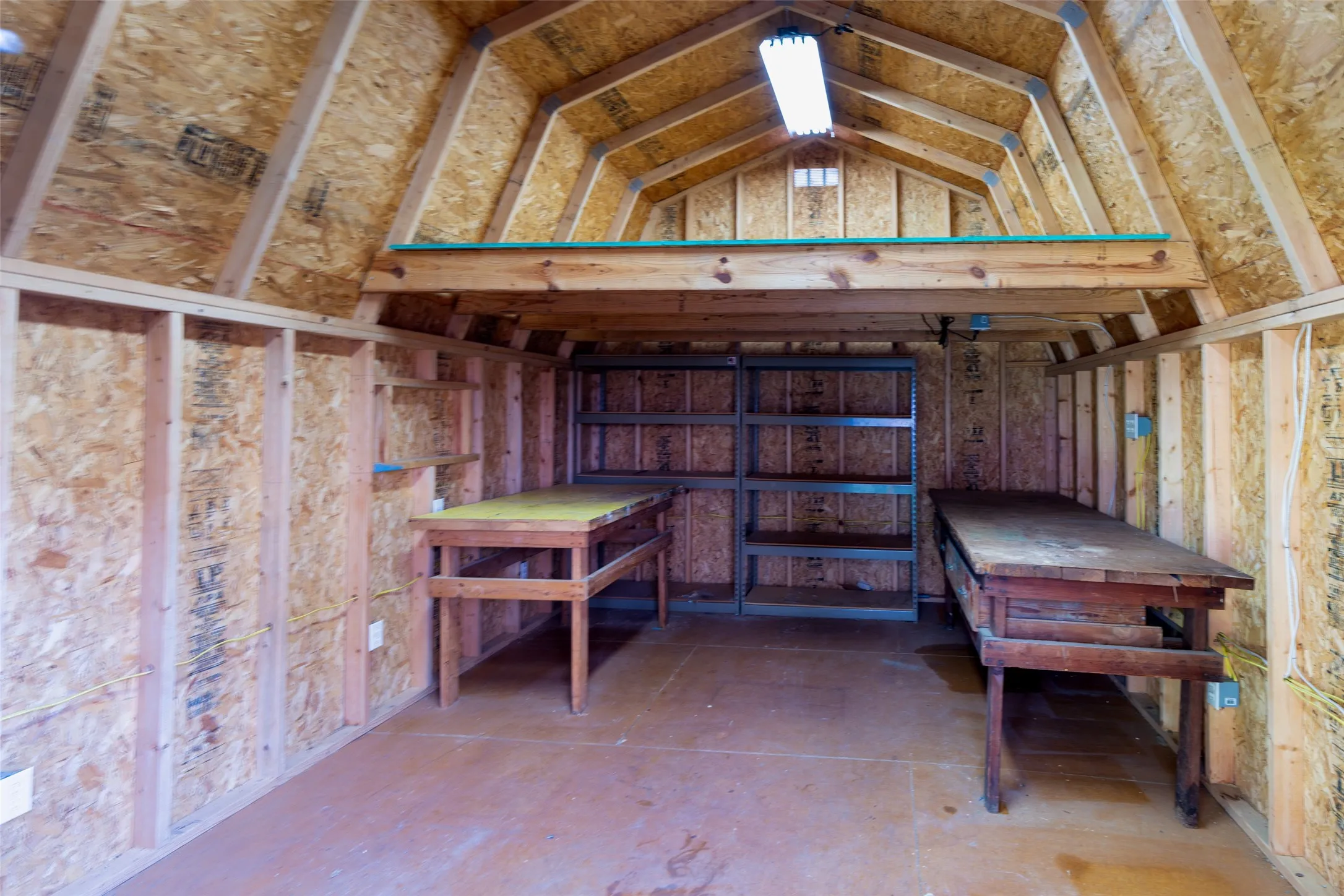 Dedicated workshop with electricity, built-in workbenches, shelving, and loft storage for tools and equipment