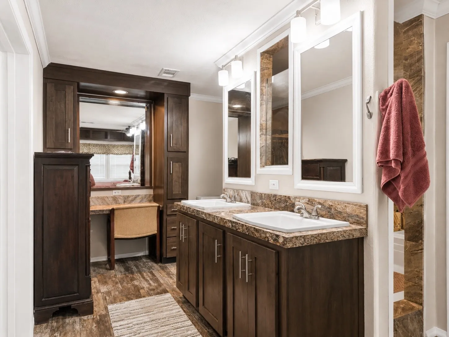 Dual vanity with rectangular sinks, detailed wood-finish cabinetry, and stone-finish countertops
