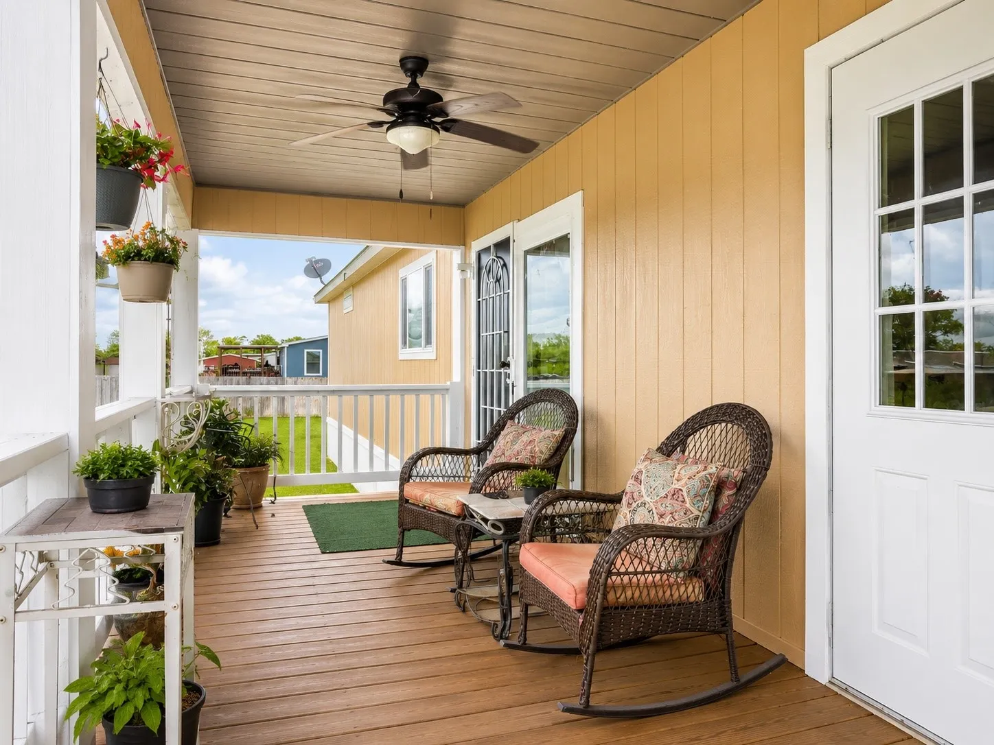 Covered porch with wood-finish decking and a ceiling fan