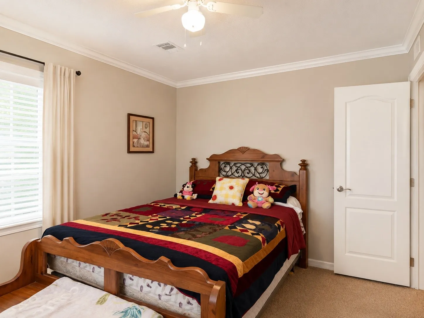 Room featuring carpet flooring, painted walls, crown molding, a ceiling fan with integrated lighting, and a white paneled door